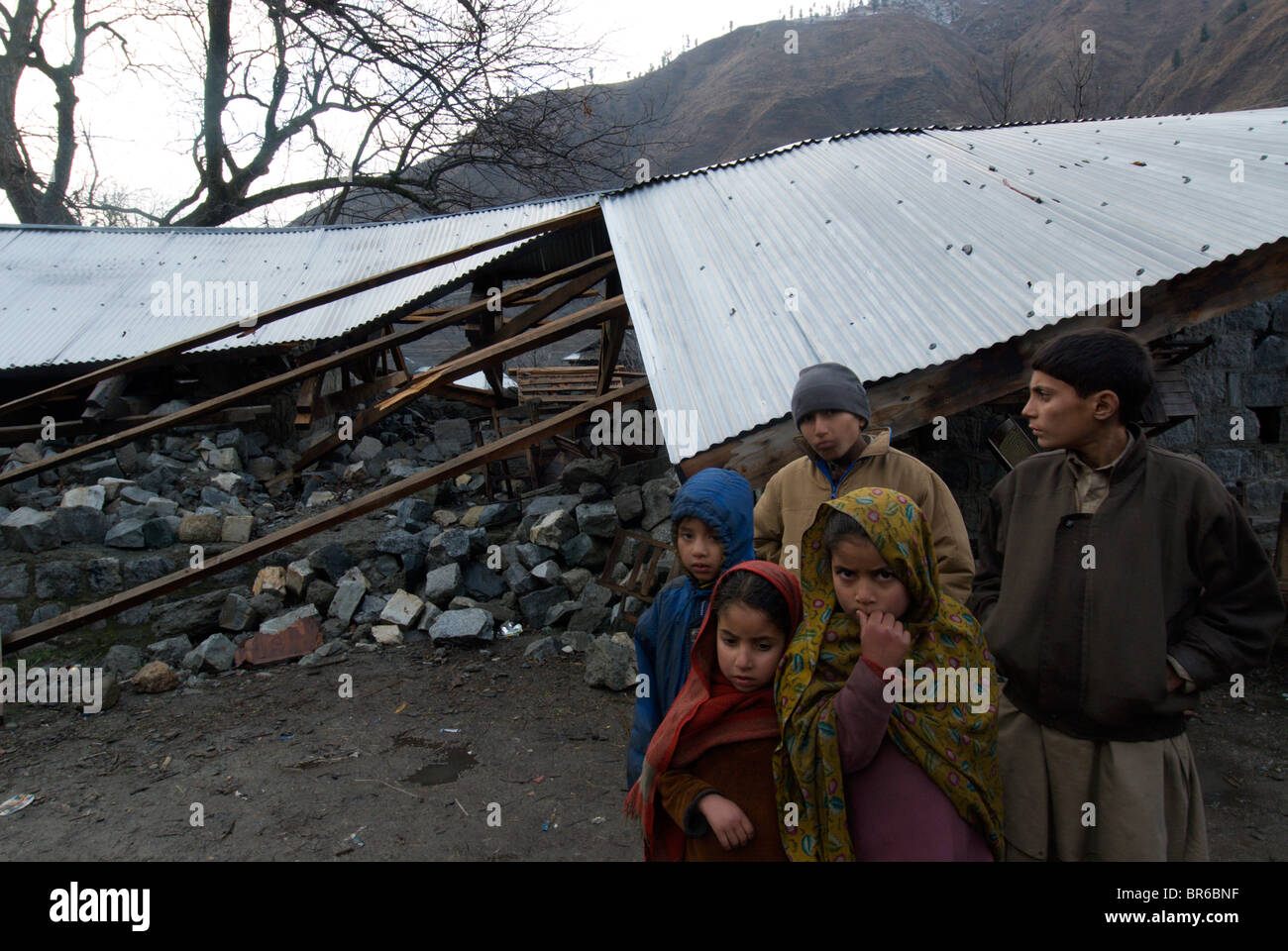 Kashmiri children stand next to a school that collapsed in the 2005 earthquake Leepa Pakistan Stock Photo