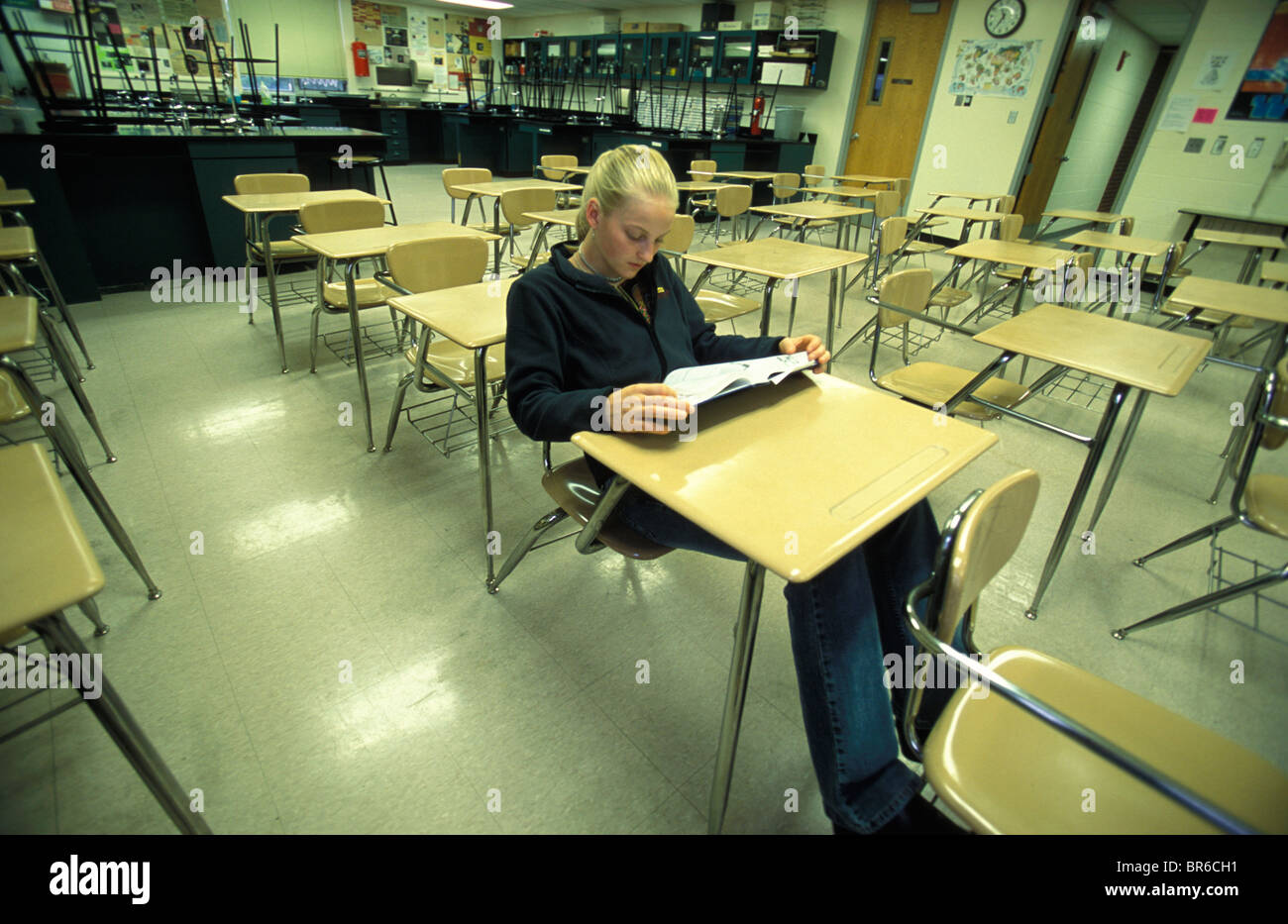 A teenage girl sits at a desk in an empty classroom Stock Photo - Alamy