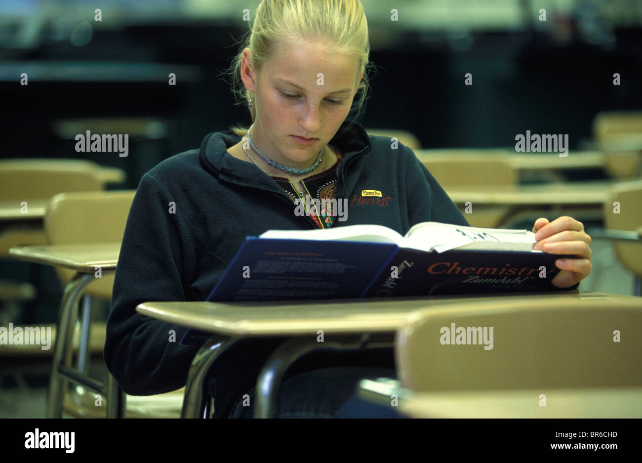 A teenage girl sits at a desk in an empty classroom Stock Photo - Alamy