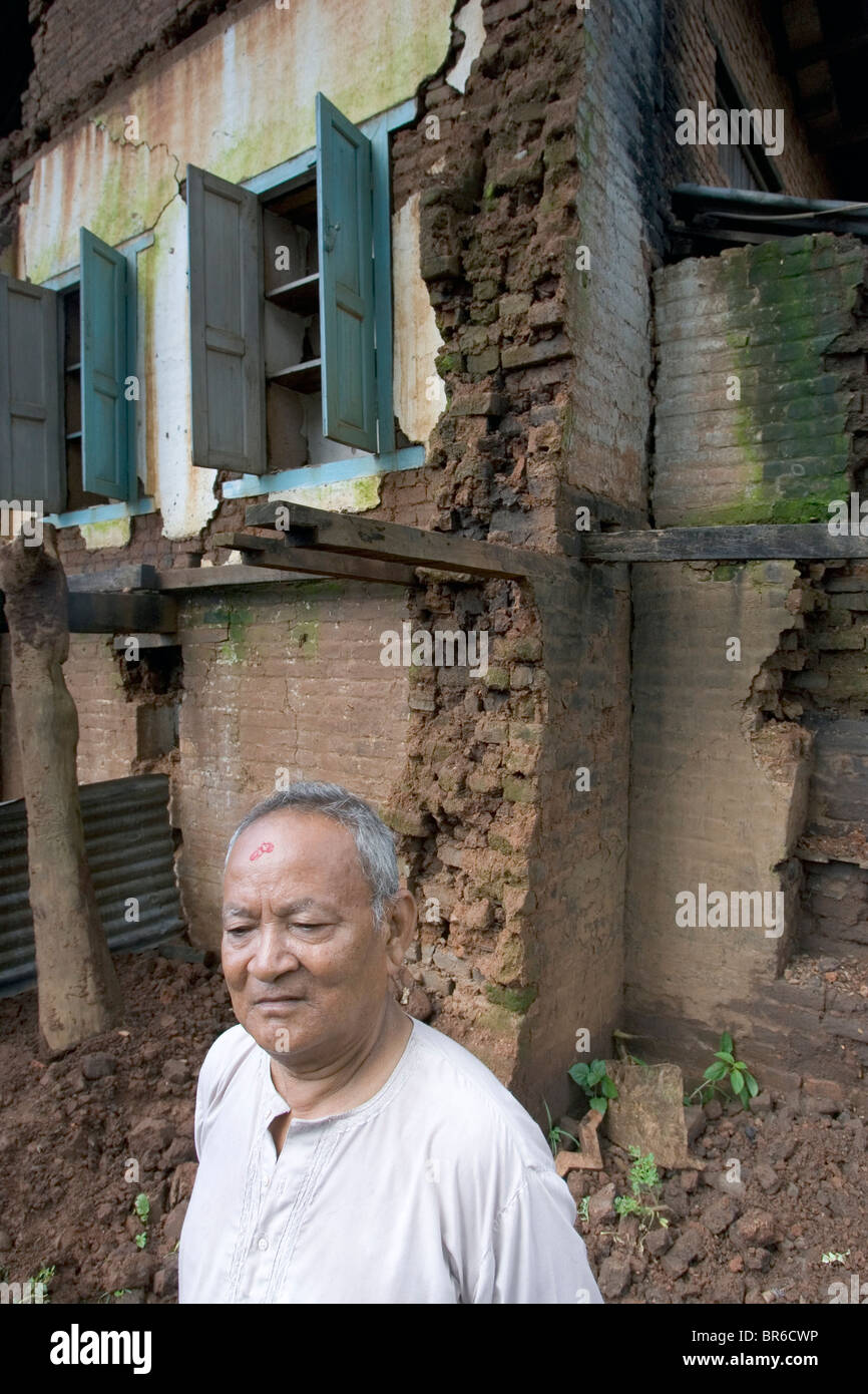Nepali man in front of Earthquake-damaged home. Stock Photo