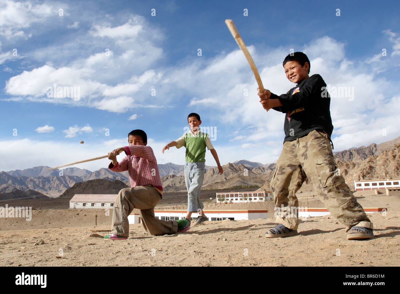 Boys play cricket in the sand outside of Leh in Ladakh, India. Stock Photo