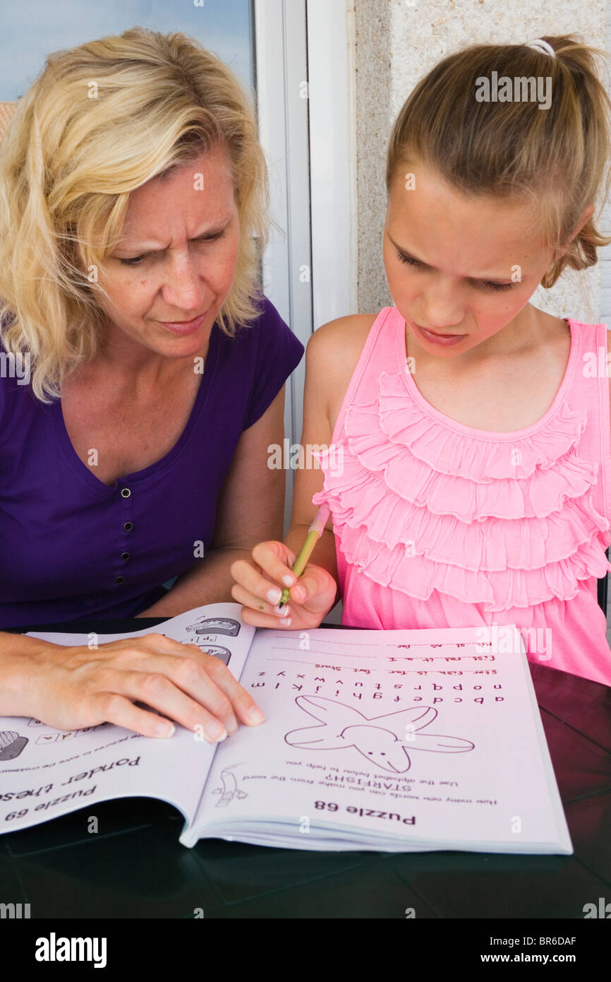 Mother and daughter doing puzzle book together. Stock Photo