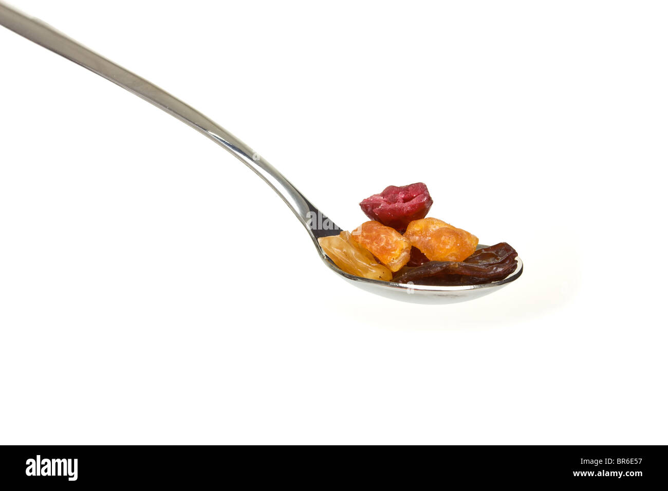 Silver spoon piled with mixed dried fruits isolated on white. Stock Photo