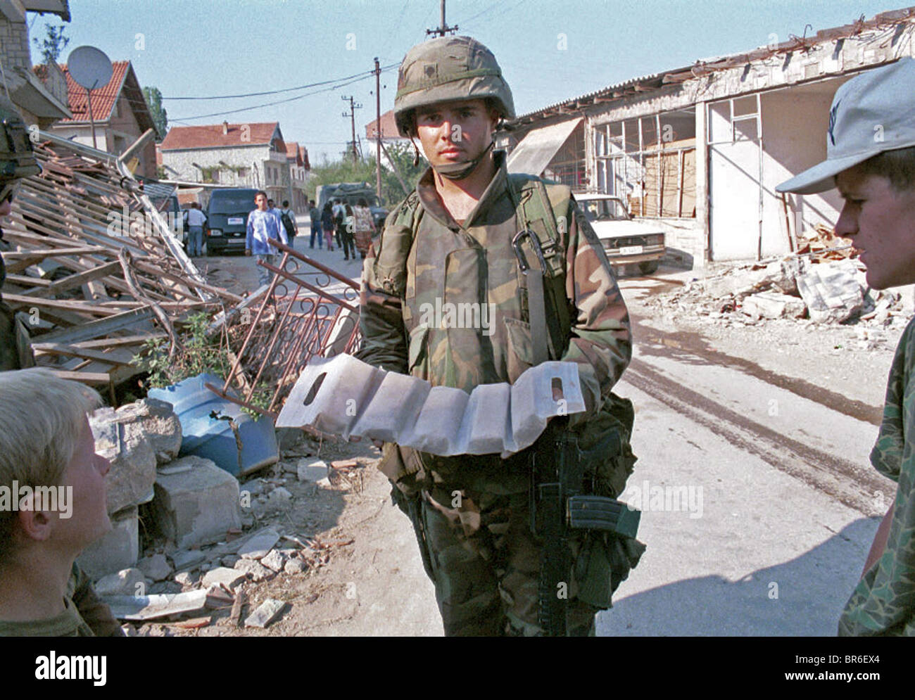 An American soldier removes plastic explosives from a bombed building outside Pristina, Kosovo. Stock Photo