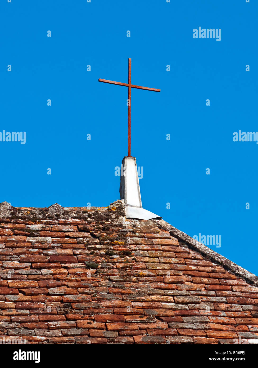Plain wrought iron cross on house roof - France. Stock Photo