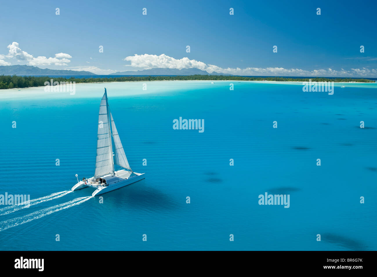 Catamaran sailing boat in the clear blue water lagoon of Bora Bora Stock Photo