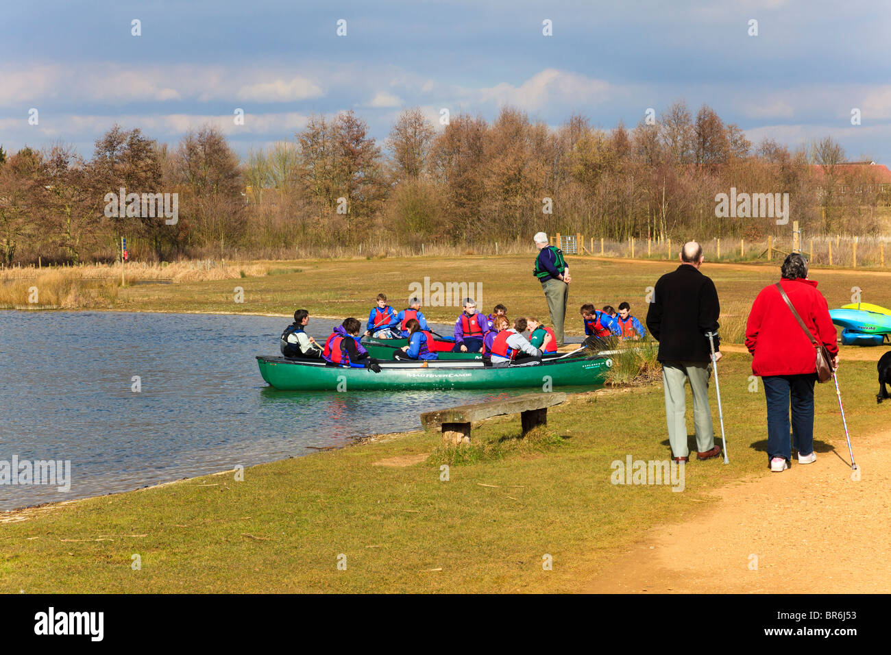 Elderly disabled couple pass School students Canoeing on the lake at