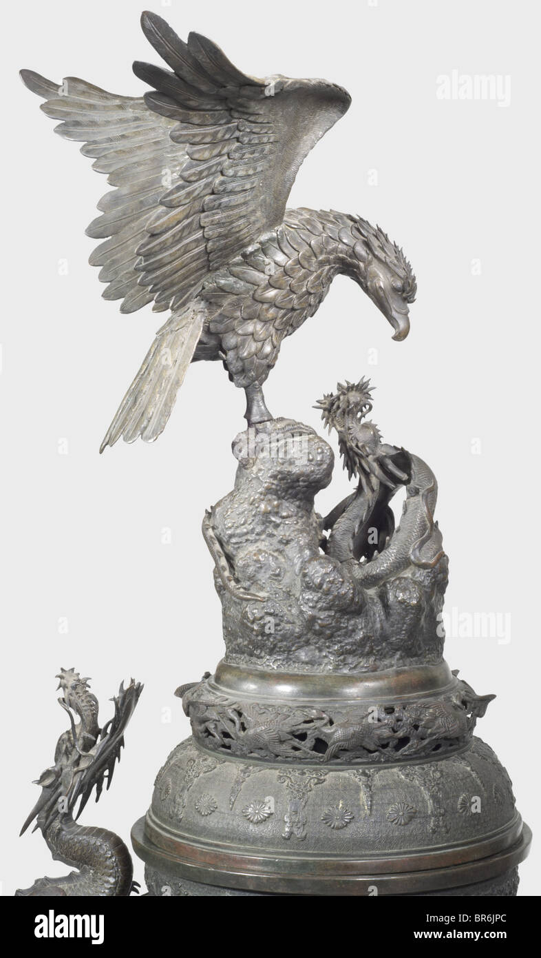A Japanese floor vase, 19th century. Patinated bronze cast in several pieces. Three-dimensionally worked lid displaying a Phoenix and a dragon. Ornamented bellied corpus sectioned into four fields bearing plants and birds in relief. Inserted handles shaped as dragons on each side (one leg of a dragon broken but included). Tall, detachable base in relief with surrounding depictions of dragons with fully plastic heads (one head included but loose, one fixed with screws). Another three-dimensional dragon winds itself between corpus and base. Small defects, repairs, Stock Photo
