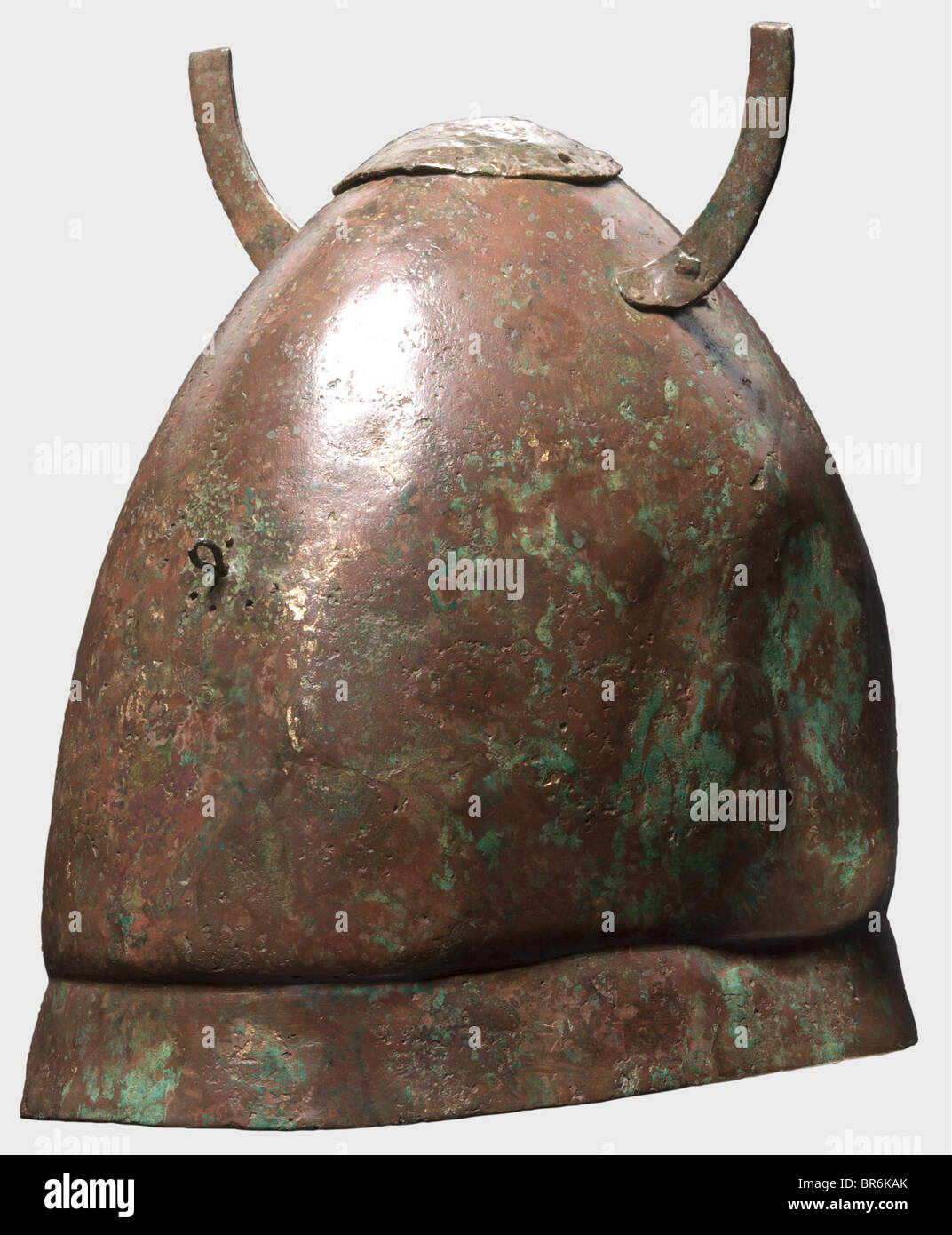 A Hellenistic Pilos type helmet, , 4th/3rd century B.C. Helmet with a high skull and a small offset lower rim. On the helmet crown a superimposed reinforcement plate attached with four rivets and three holes for the crest holder. On each side a riveted horn-shaped plate lug. A loop on both front and back, above the helmet base a hole on either side for the chin strap attachment. Height 21.7 cm, weight 720 g. Bronze. Red-brown to green patina. Supplements to the rim area and in the skull. The interior reinforced with fibreglass. Slightly deformed. Axel Guttmann , Stock Photo
