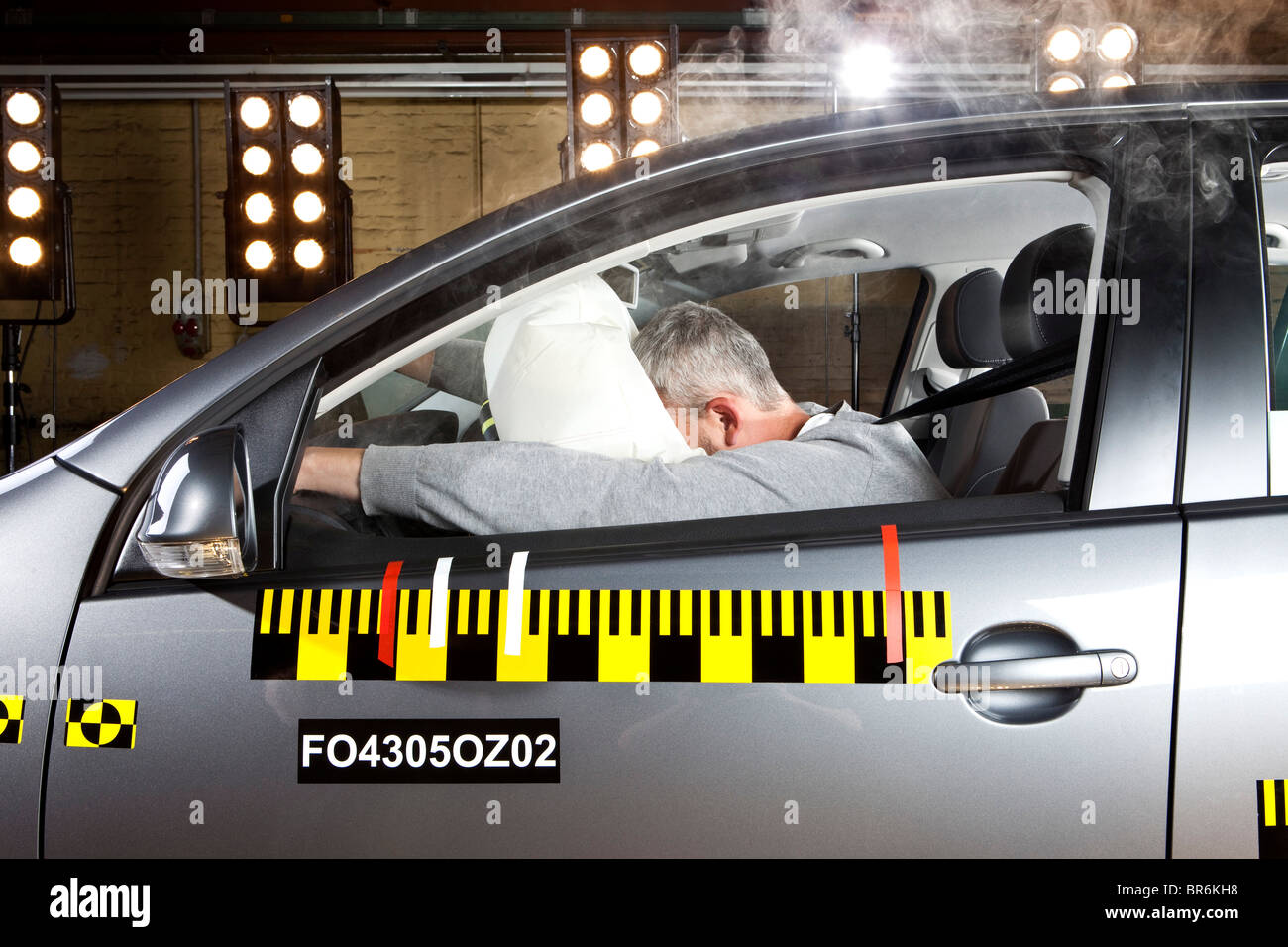 A man's face impacting an airbag in a crash test car Stock Photo