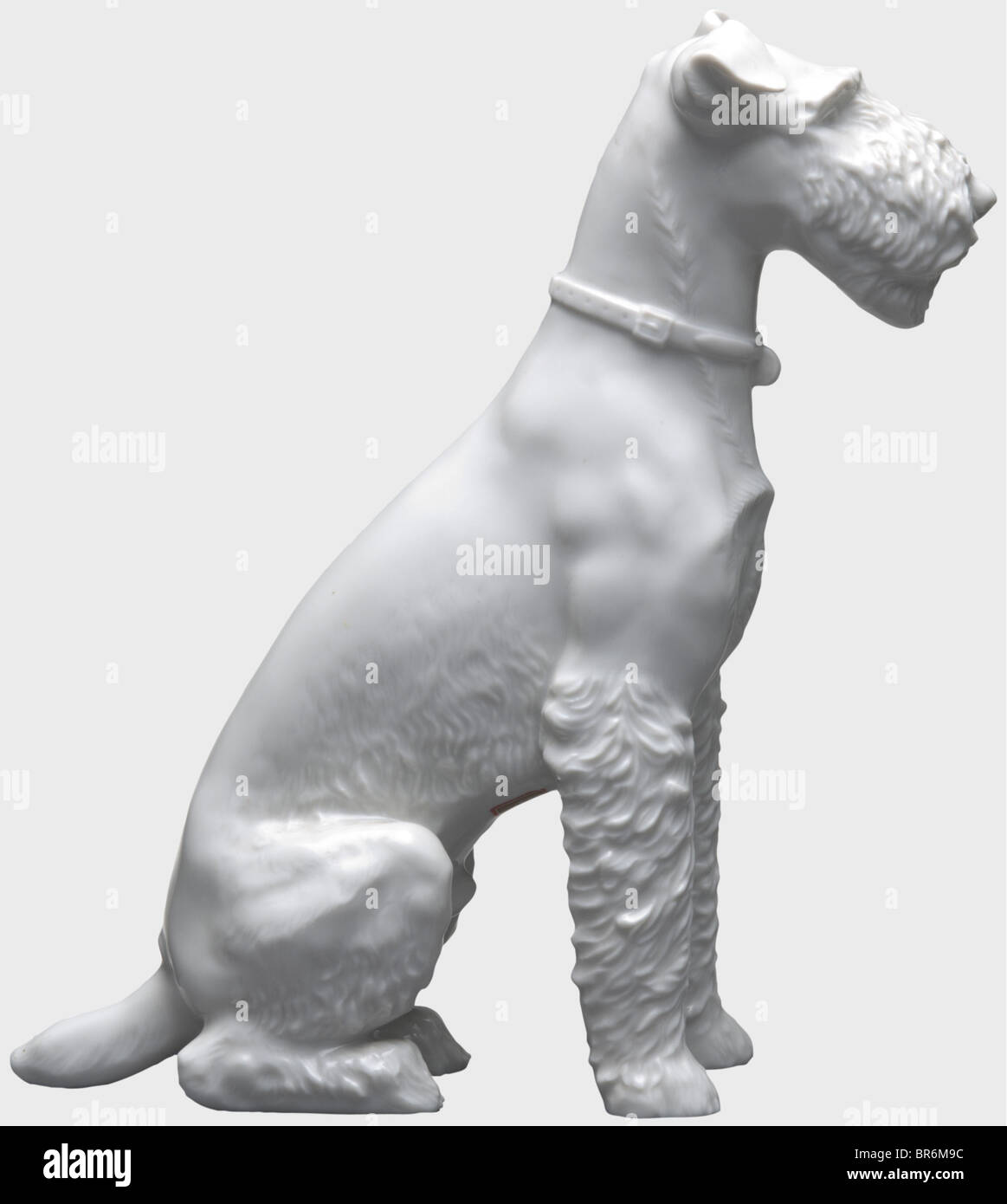 A sitting fox terrier, design by Franz Nagy, model number '105'. White, glazed porcelain. On the underside of the paws monogrammed 'FNY', model number and manufacturer's mark 'SS Allach' in underglaze green. Heigth 22 cm. Absolutely undamaged. On the belly the so far unknown selling label (transl.) 'Arts and Crafts Edith Bäzel Litzmannstadt - Wartheland'. historic, historical, 1930s, 1930s, 20th century, object, objects, stills, clipping, clippings, cut out, cut-out, cut-outs, Stock Photo