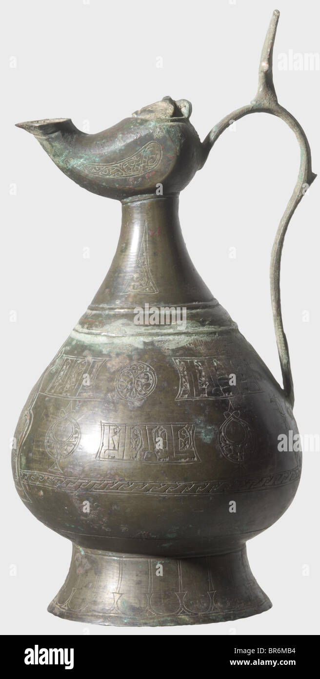 An engraved, pitcher-shaped bronze oil lamp, Khorasan circa 1200. Drop-shaped body with conical foot, lateral handle and engraved cartouches along the periphery bearing ornaments and inscriptions, respectively. The front with the image of a mythical creature surrounded by a palmette-shaped copper frame. On the neck a small oil lamp with hinged lid. Brown-green patina. Height 24 cm. historic, historical, 13th century, Ottoman Empire, object, objects, stills, clipping, clippings, cut out, cut-out, cut-outs, Stock Photo