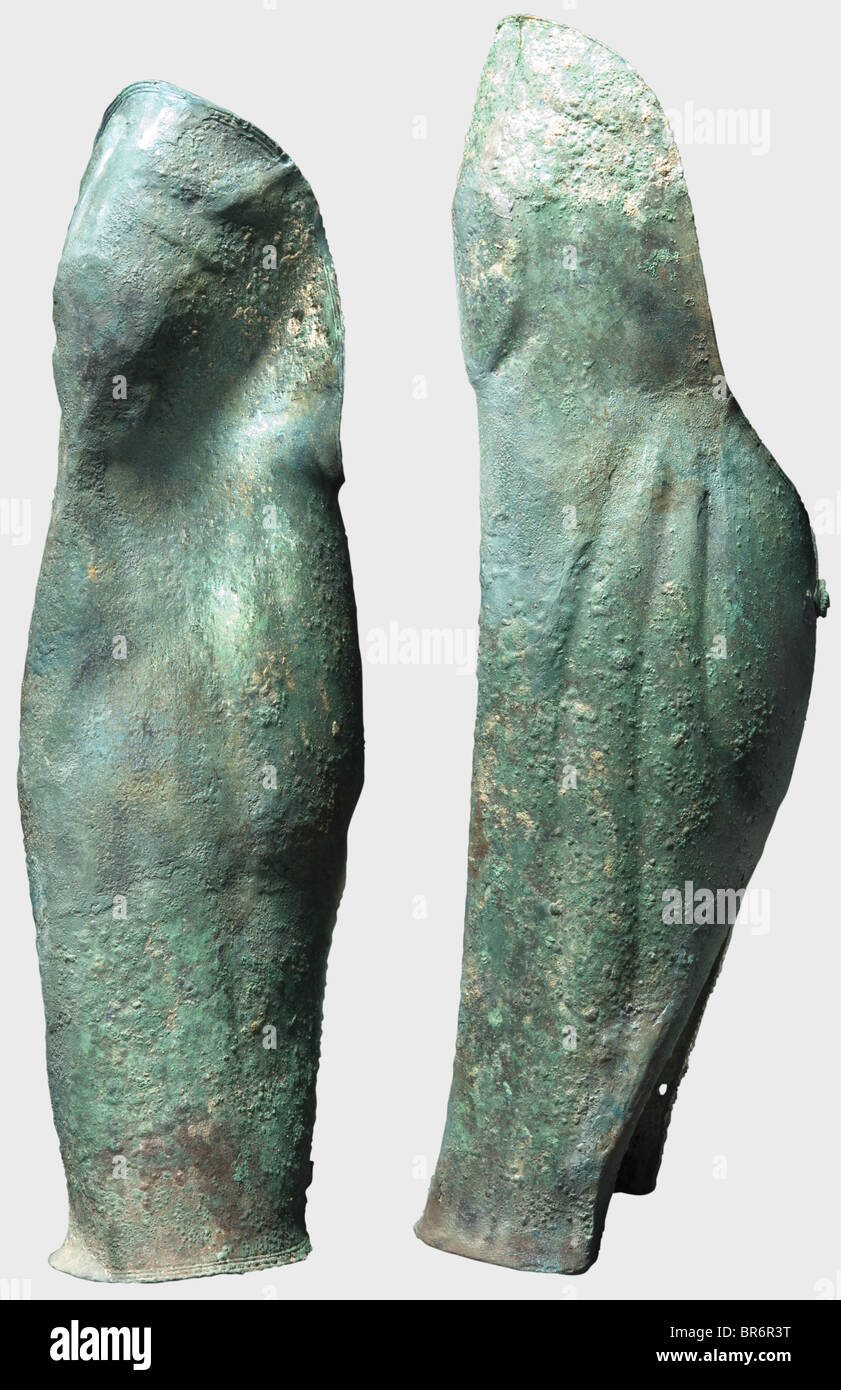 A pair of Greek bronze greaves, , 5th/4th century B.C. Greaves formed with  anatomical details with emphasis of the muscles and a fine, three-lined  border along the perimeter. On the back two