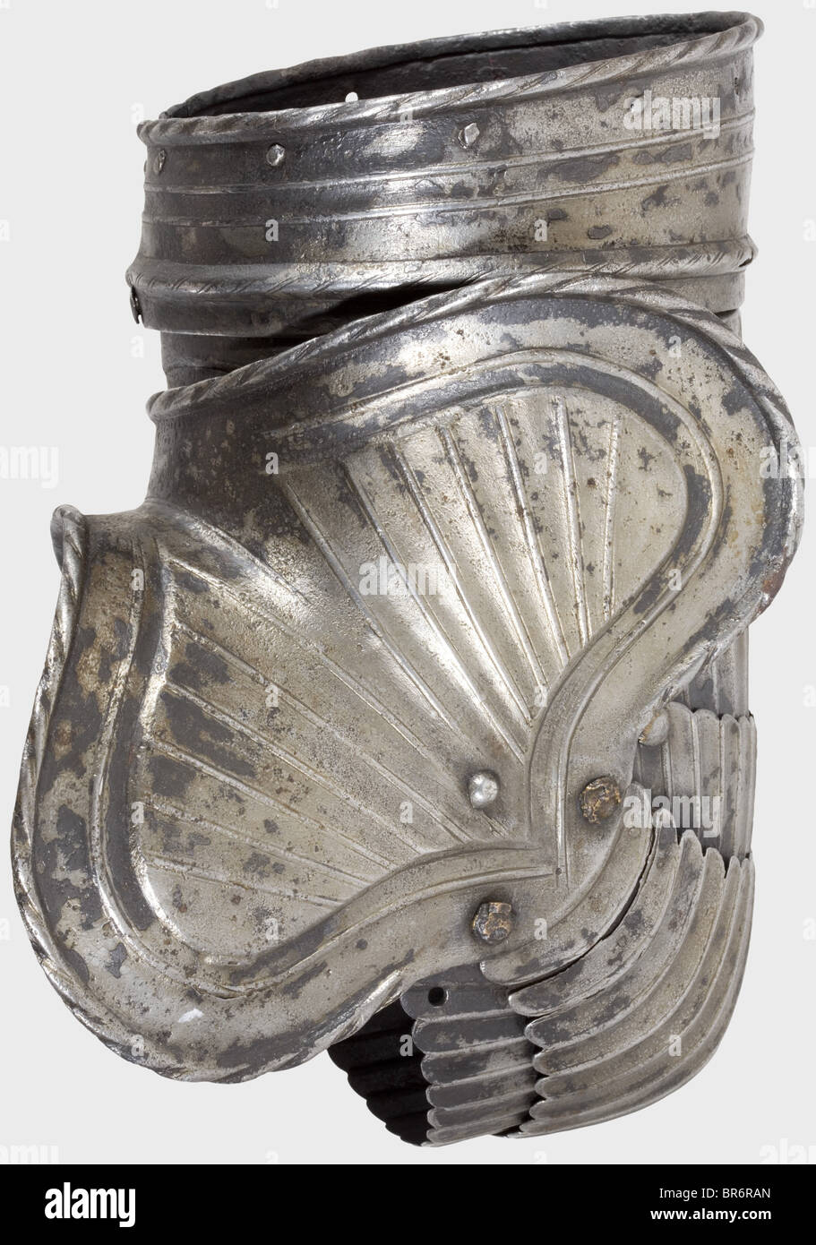 Arm defences of a Maximilian armour, Germany, circa 1520. Fragment of a left arm defence consisting of a complete rerebrace and a large couter. Matching pieces with fine fluting. Damaged by fire. Ridges partially ground through. Length 27 cm. historic, historical, 16th century, defensive arms, weapons, arms, weapon, arm, fighting device, object, objects, stills, clipping, clippings, cut out, cut-out, cut-outs, utensil, piece of equipment, utensils, plating, armour-plating, armour, armor, reactive armour, armour suit, armor suit, metal, Stock Photo