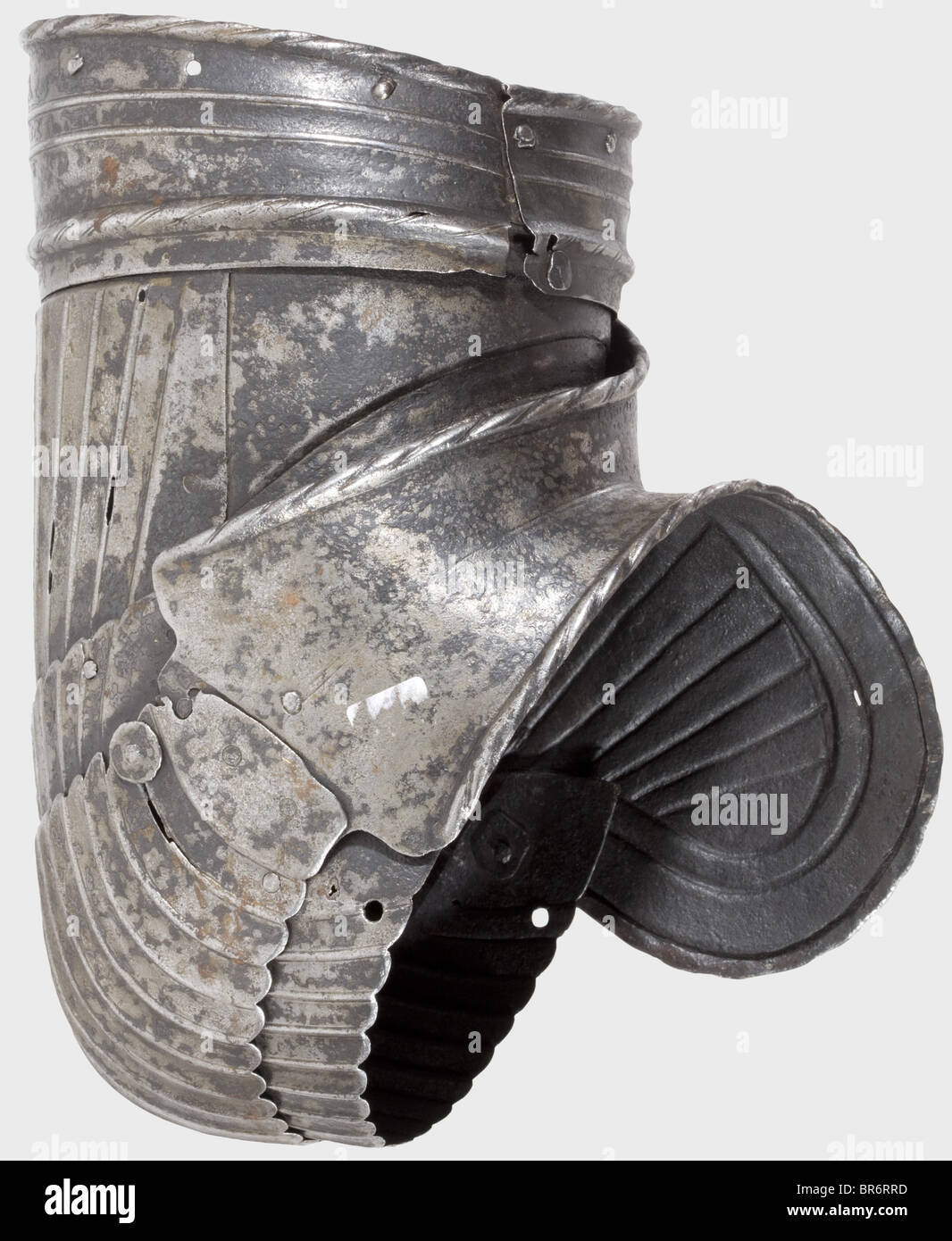 Arm defences of a Maximilian armour, Germany, circa 1520. Fragment of a left arm defence consisting of a complete rerebrace and a large couter. Matching pieces with fine fluting. Damaged by fire. Ridges partially ground through. Length 27 cm. historic, historical, 16th century, defensive arms, weapons, arms, weapon, arm, fighting device, object, objects, stills, clipping, clippings, cut out, cut-out, cut-outs, utensil, piece of equipment, utensils, plating, armour-plating, armour, armor, reactive armour, armour suit, armor suit, metal, Stock Photo