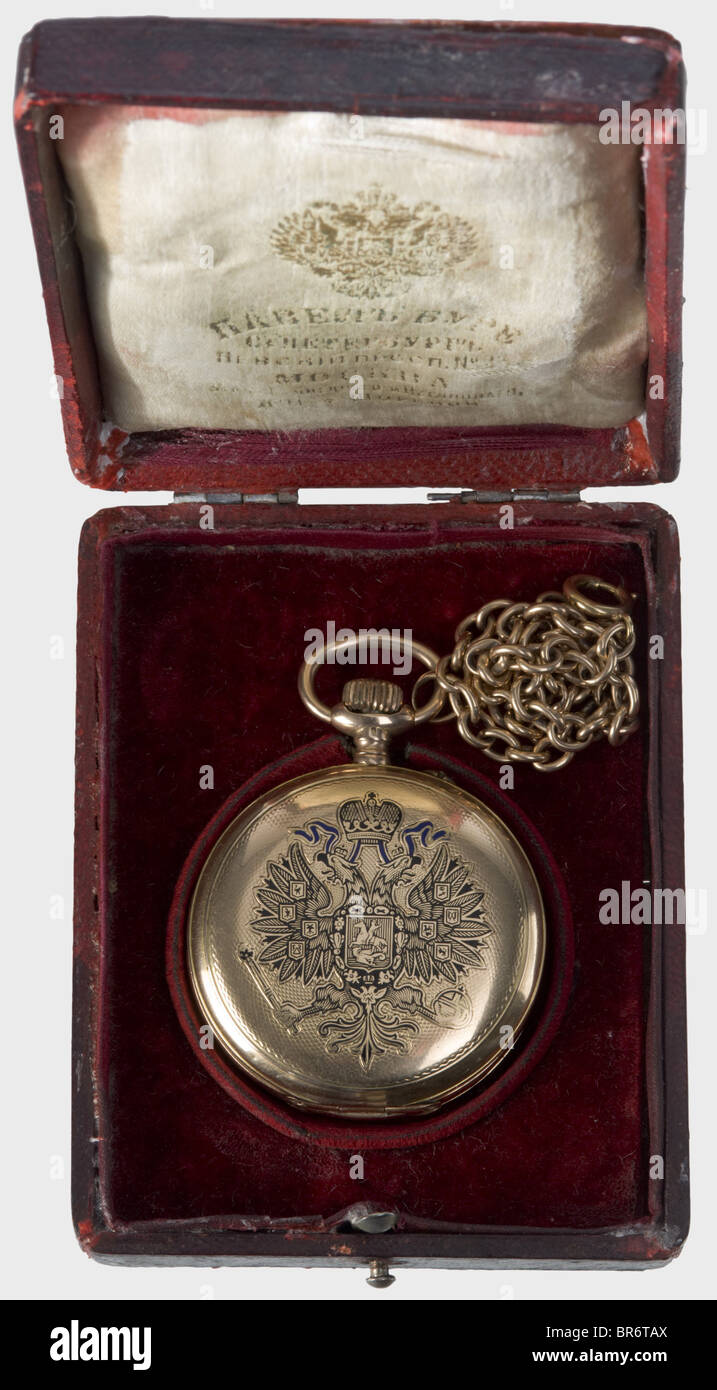 A golden savonette pocket watch with Imperial Russian double-headed eagle, Pavel Bure, Court Watch Maker to the Imperial House. The lid bears the Tsarist double eagle partially enamelled in blue and black. White enamel dial (fissures) with gold hands, black Roman and Arabic numerals, as well as small second. Working, jewelled precision movement. Engraved on the back with serial number '203521', and mark of fineness '0,583'. Golden watch chain. In a damaged red leather case with a gilt eagle on the lid. The maker's mark is stamped in gold on the silk lining. his, Stock Photo