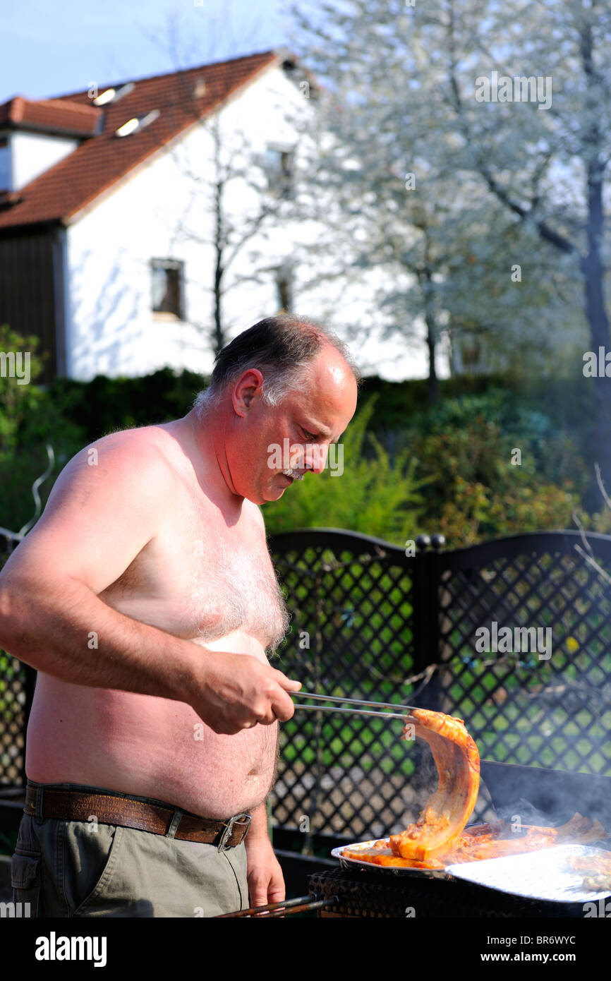 Mature Man grilling in the Garden Stock Photo