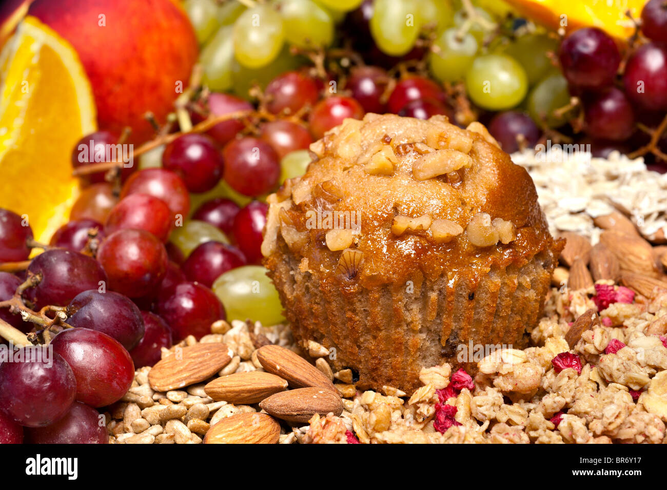 A breakfast setting of a freshly baked muffin with fruit and other condiments. Stock Photo