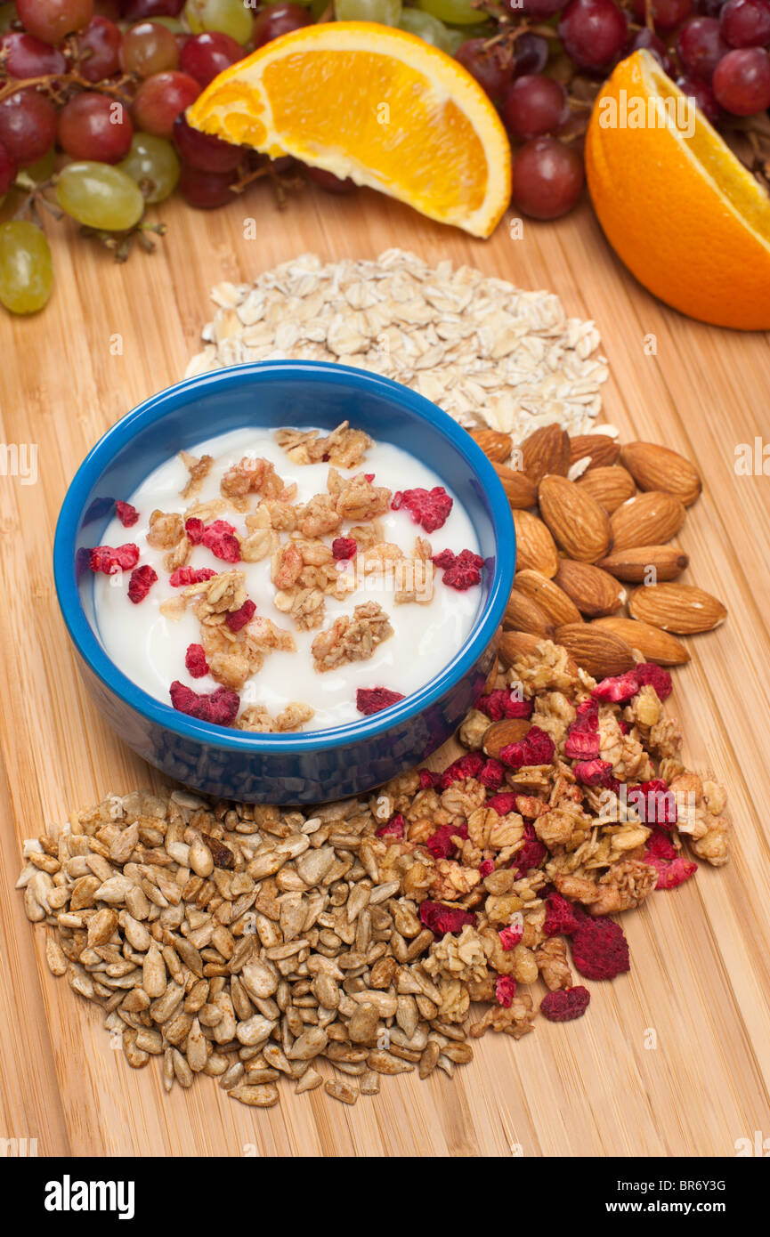 A bowl of fresh yogurt with fresh fruit and healthy additions such as almonds, oats, granola and sunflower seeds Stock Photo
