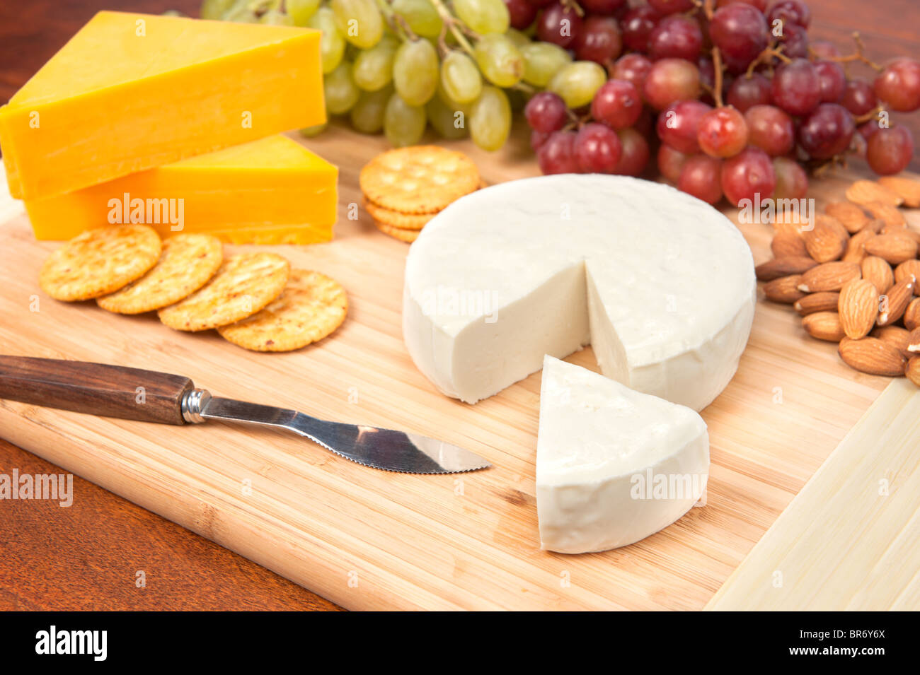 A cheese tray with fruit, crackers and almonds. Stock Photo