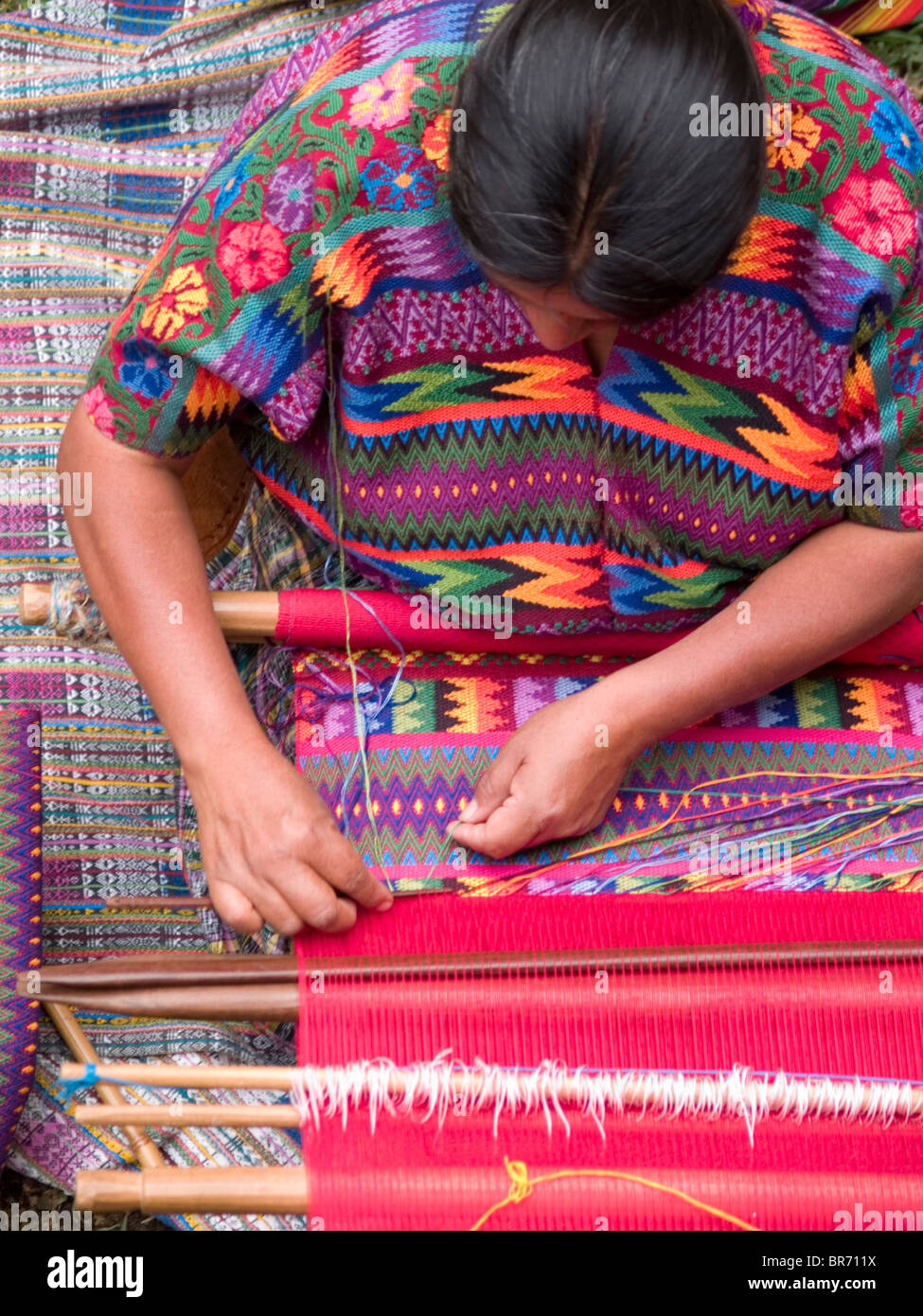 A woman from an indigenous community in Guatemala weaving while wearing