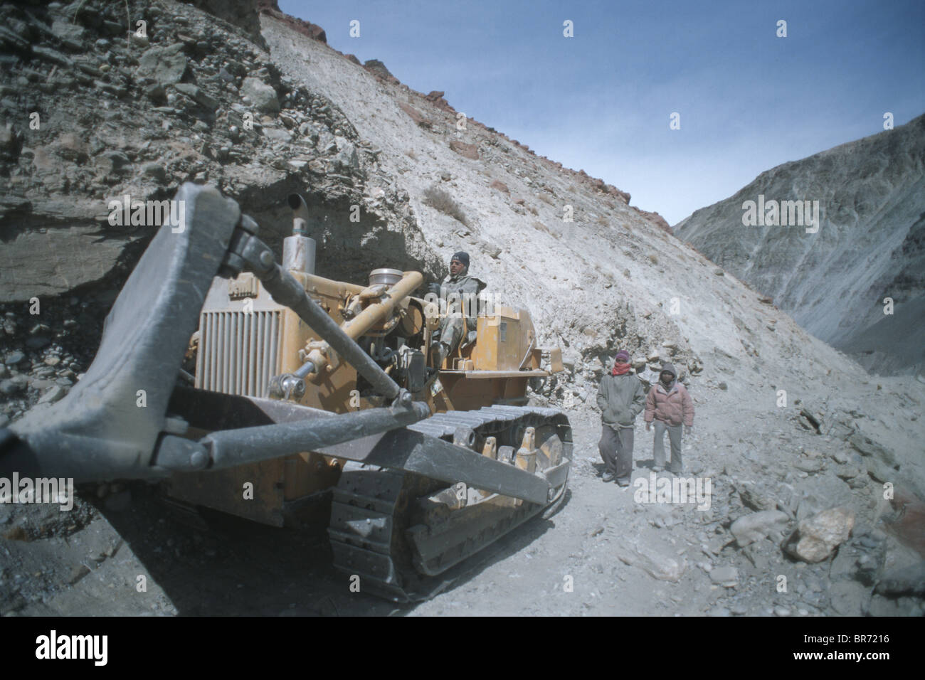 Bulldozer clearing debris on new road in Zanskar river valley Ladakh. Stock Photo