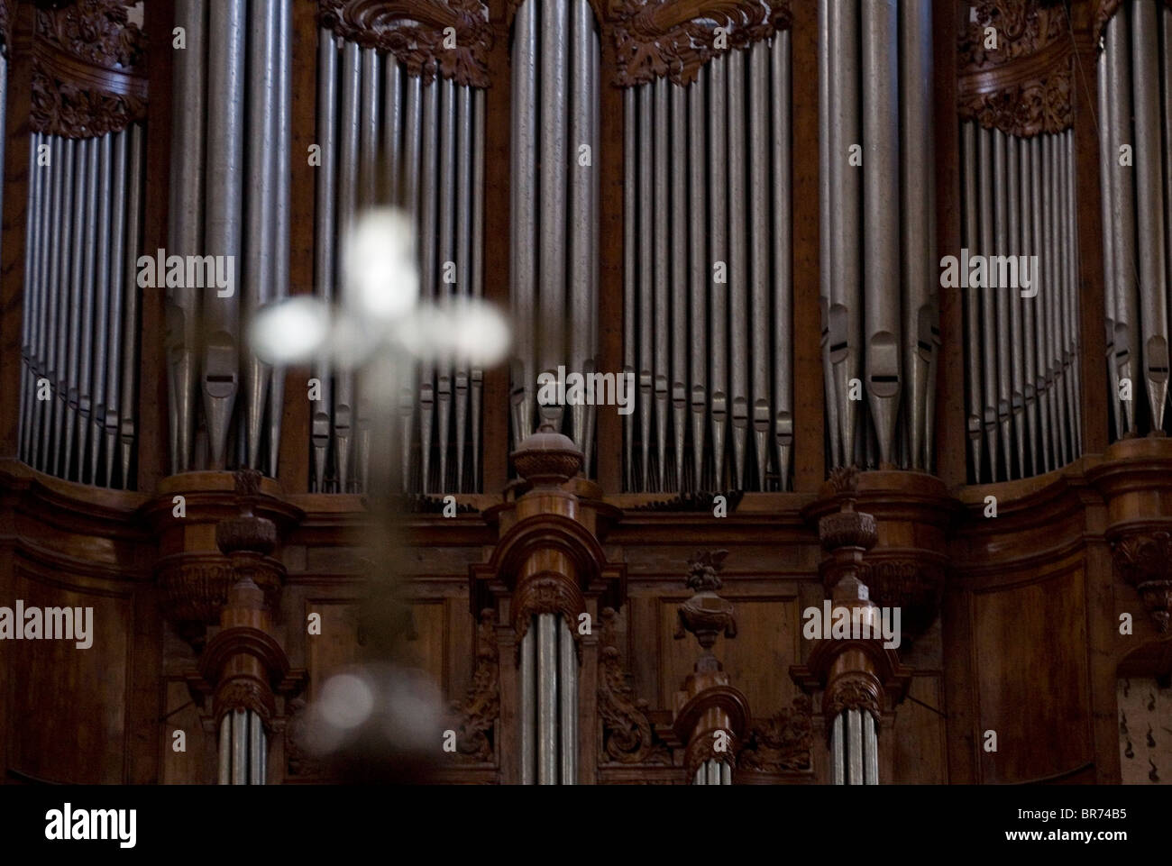 Blurred out cross infront of a large organ in Saint Maximin France. Stock Photo