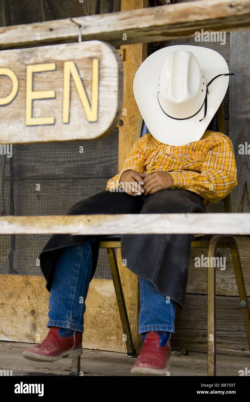 Young cow boy on porch Wyoming Stock Photo