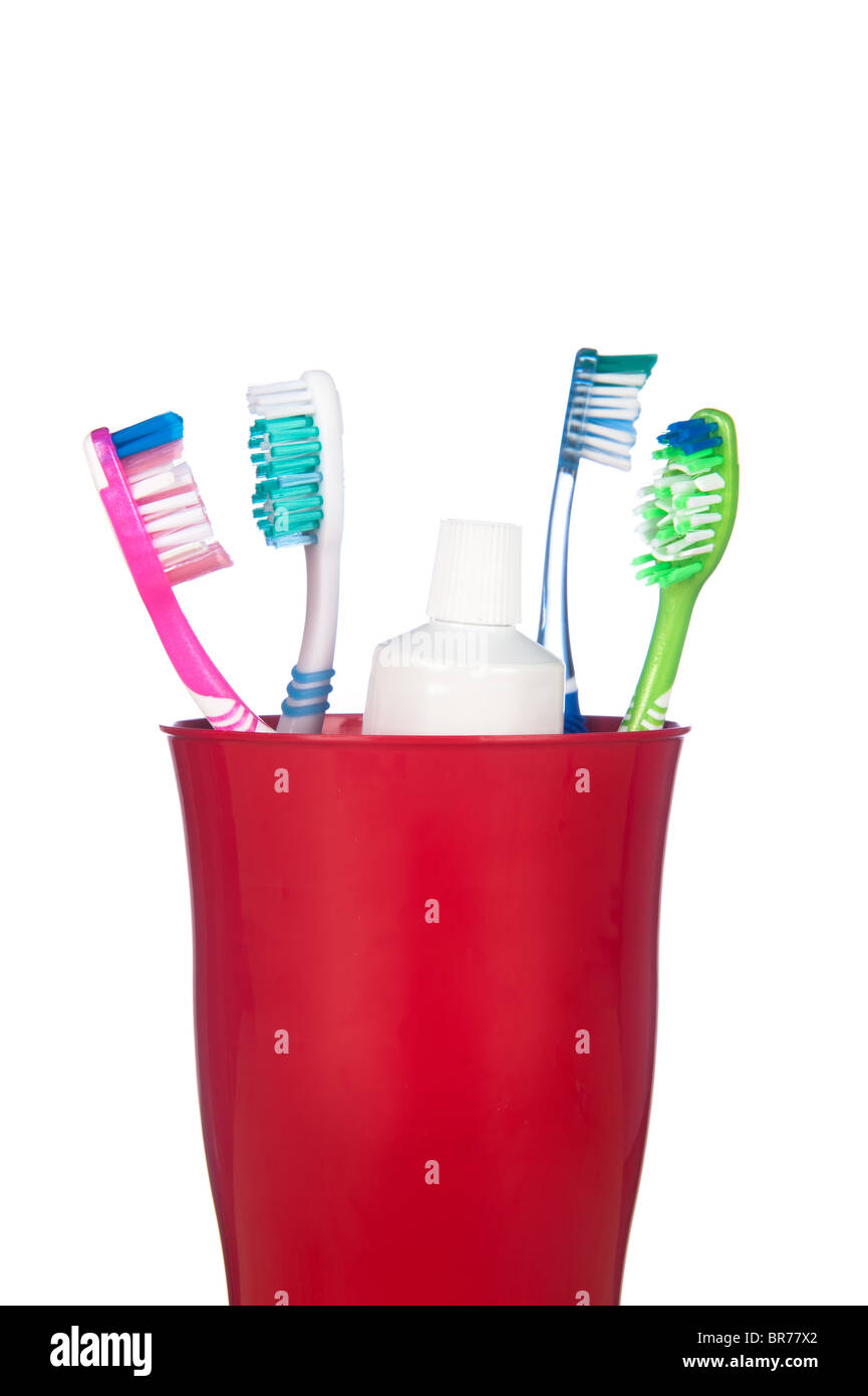Toothbrushes and a tube of toothpaste in a cup isolated on white Stock