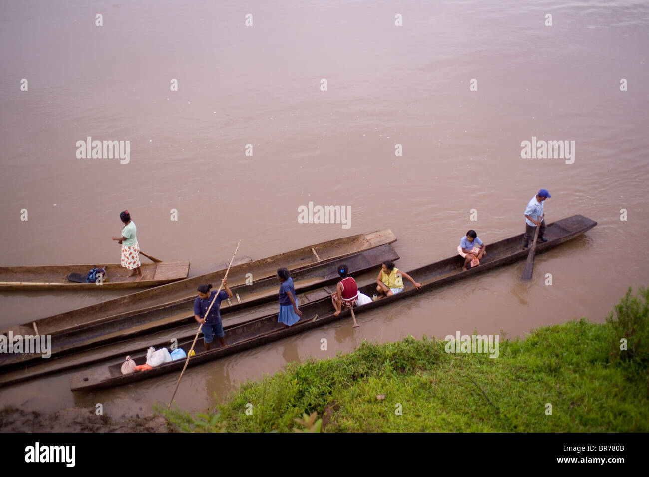Several people prepare to travel in traditional Miskito dugout canoes down the Rio Coco Nicaragua. Stock Photo