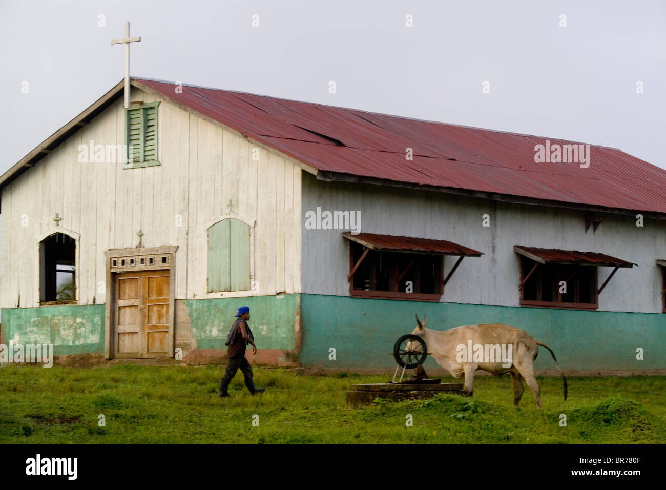 A young man passes the Catholic church in the indigenous Miskito village Krin Krin Nicaragua located on the Rio Coco. Stock Photo