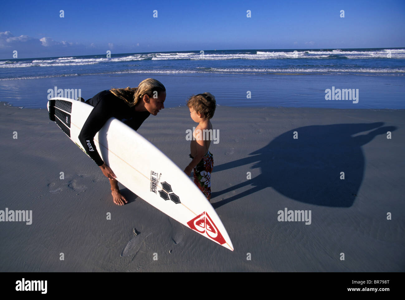 An attractive female surfer with her son at Ponce De Leon inlet in