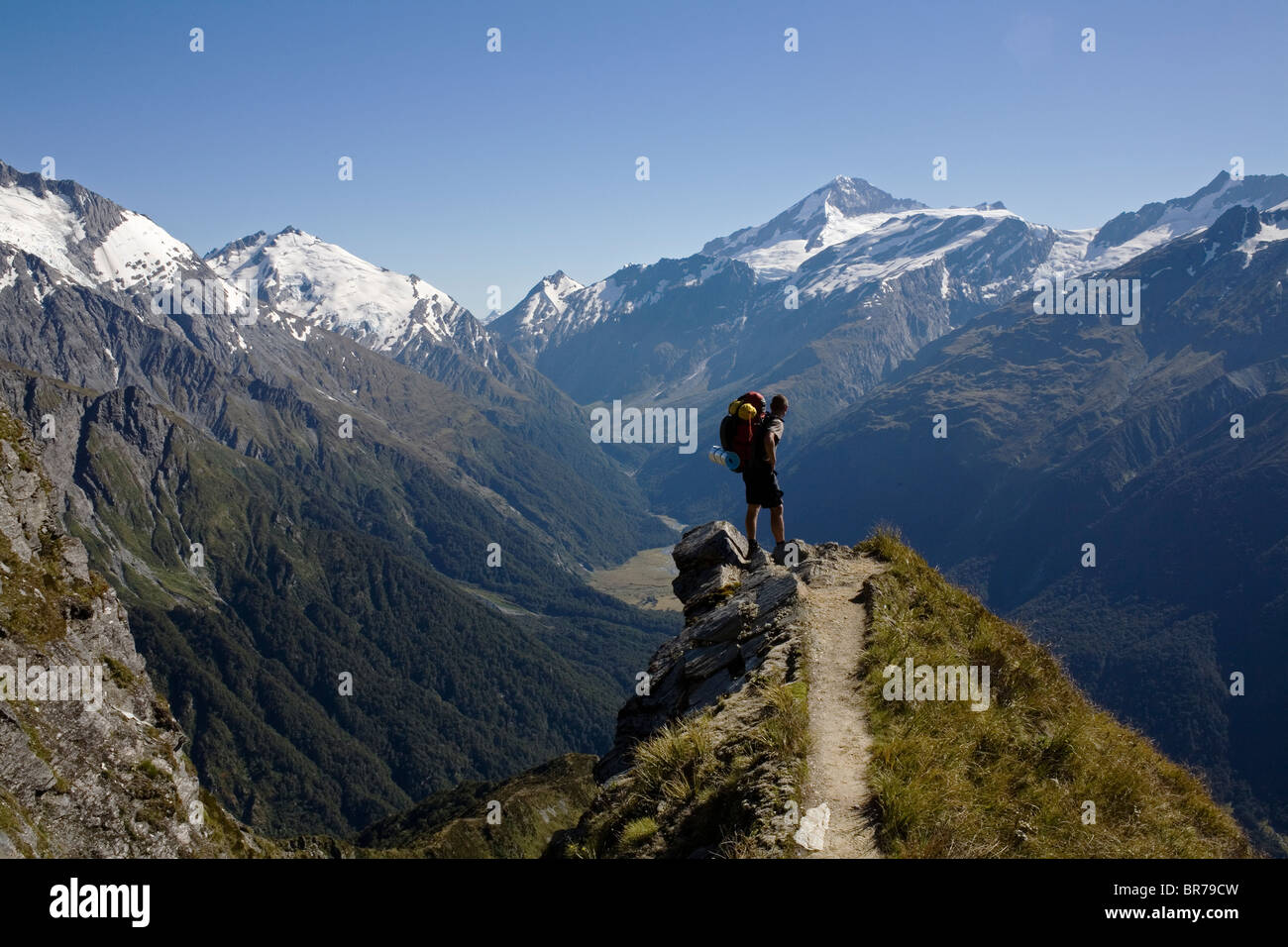 A hiker looking over the Matukituki Valley towards Mount Aspiring in the Mount Aspiring National Park. Stock Photo