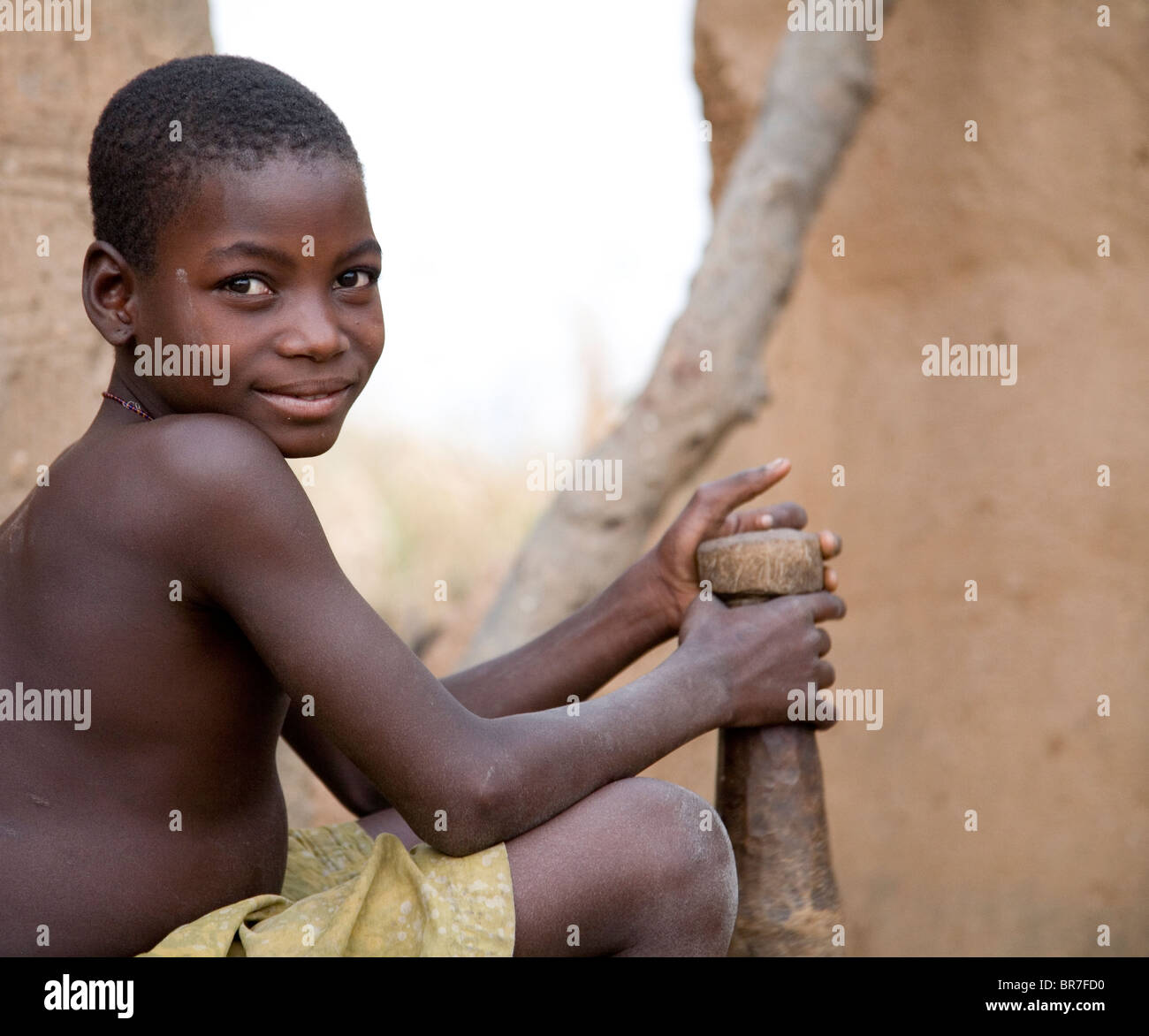Young girl pounds maize in Togo Stock Photo