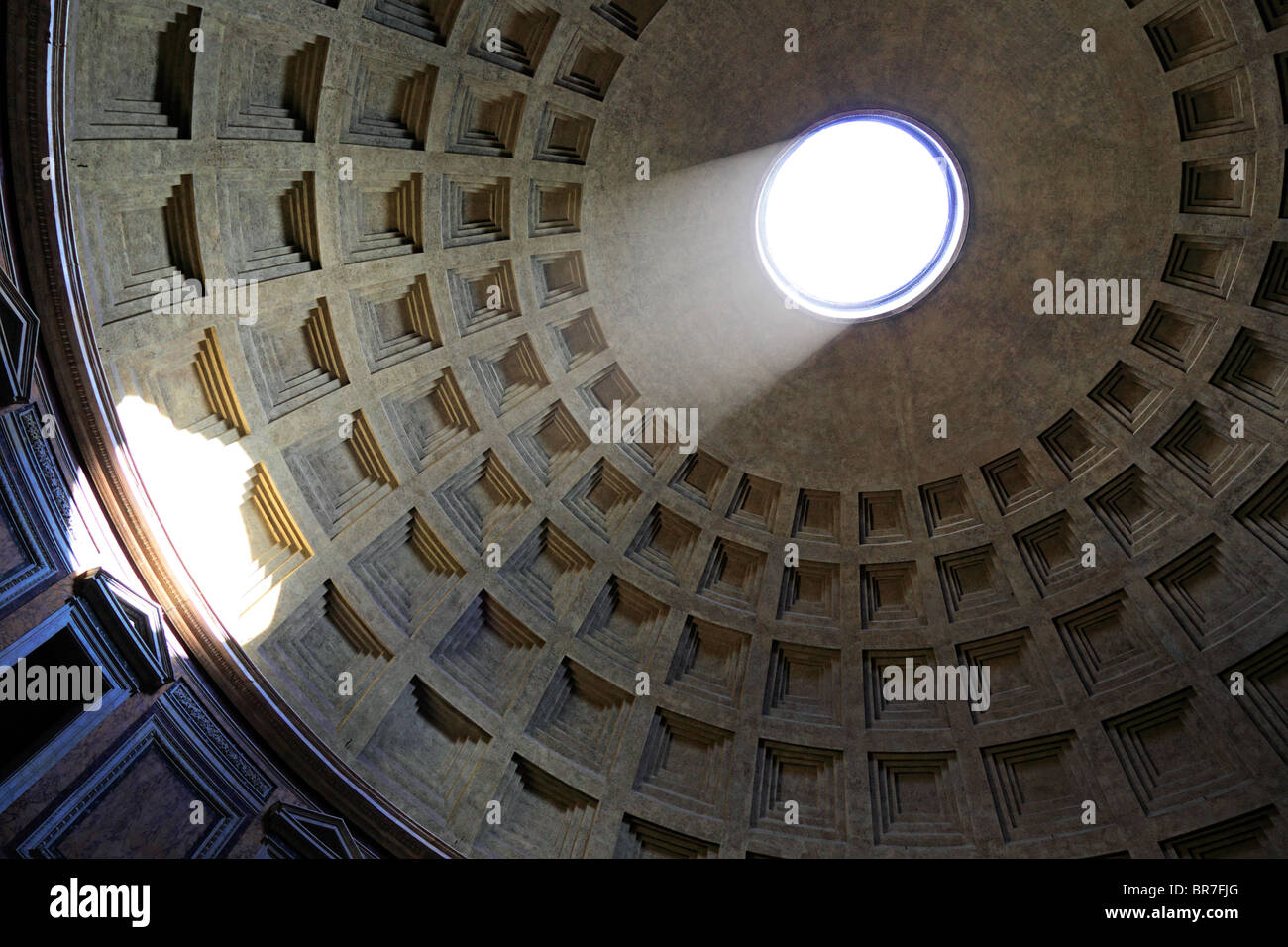 The sun illuminates the inside of the ceiling through the hole at the top of the Pantheon in Rome, Italy Stock Photo