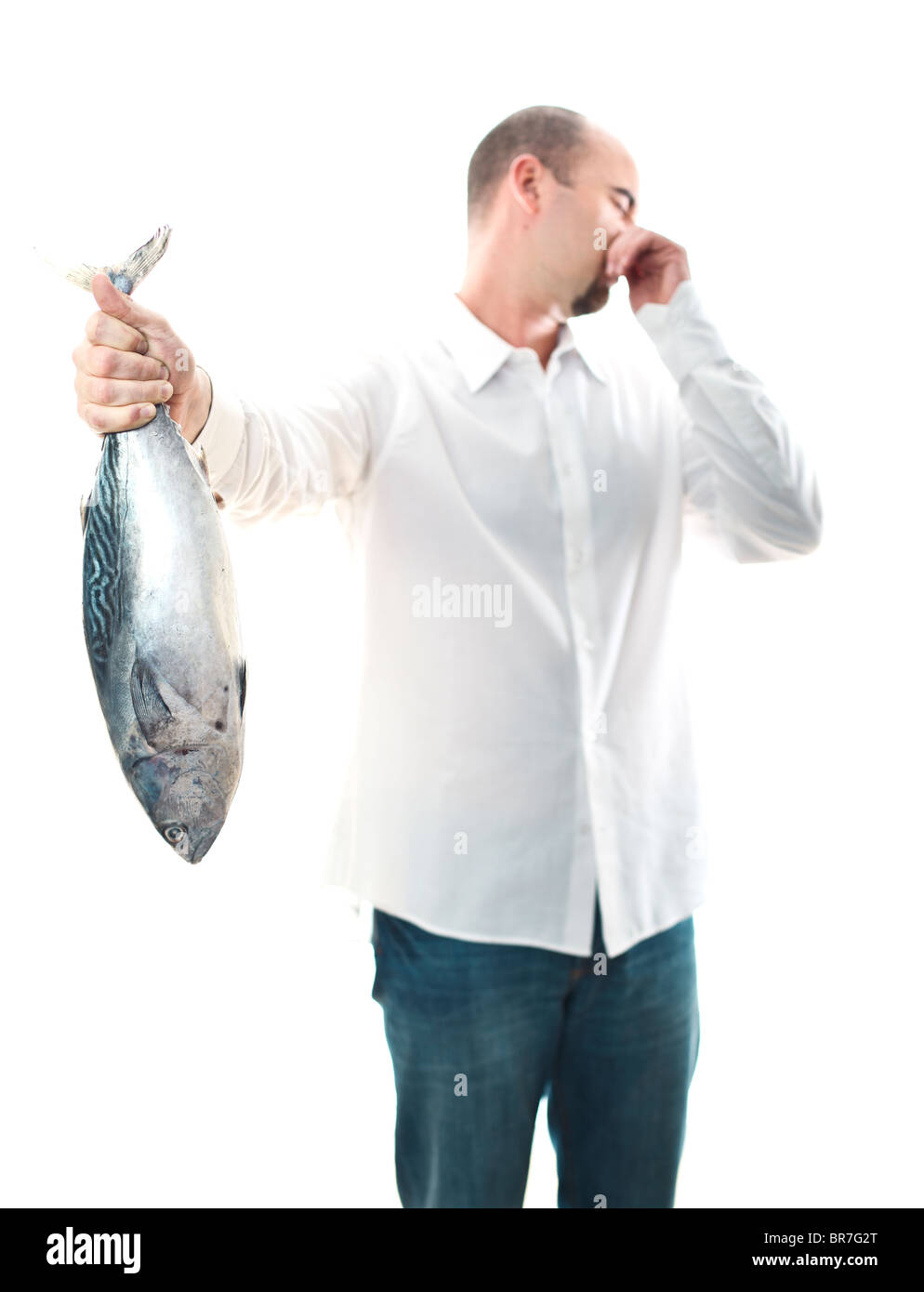 young man hold an smelly fish in his hand selective focus Stock Photo