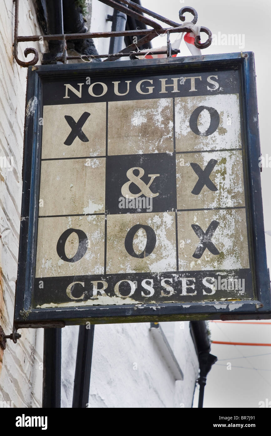 Unusual wooden pub sign outside the Noughts and Crosses public House in the fishing village of Polperro Cornwall UK Stock Photo