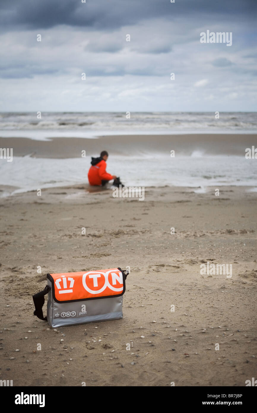 tnt postman sitting by the shore Stock Photo