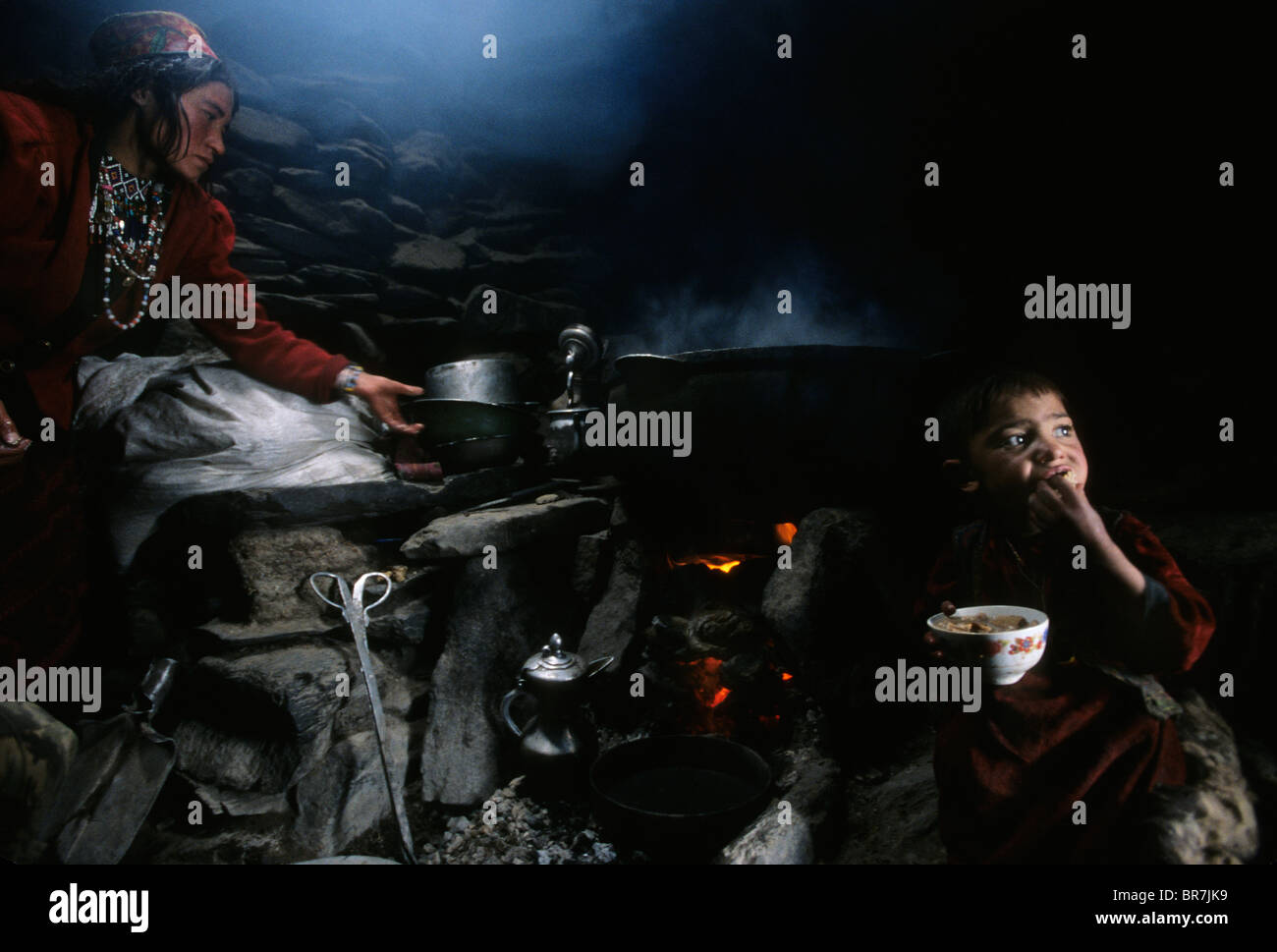 Wakhi woman and child cooking Wakhan corridor Afghanistan. Stock Photo