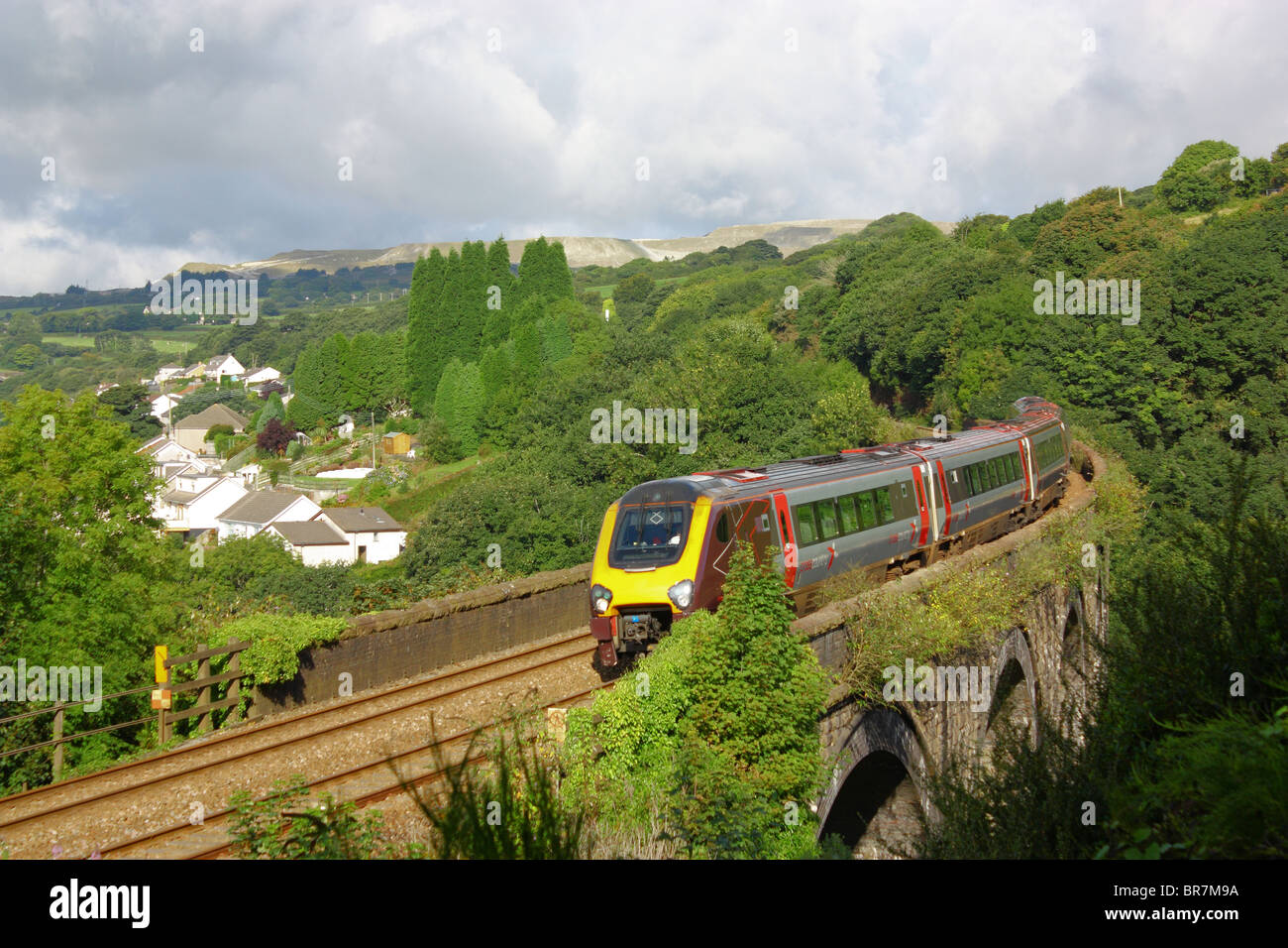 Modern diesel five carriage train crossing St Austell viaduct, Cornwall. Direction of travel towards us. Slowing for a stop in about half a mile. Stock Photo