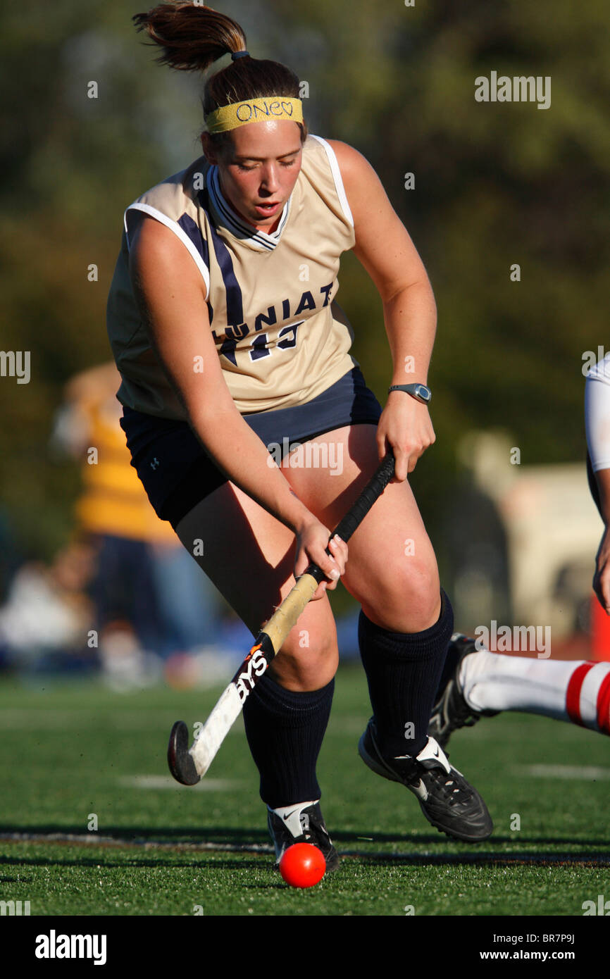A Juniata College player controls the ball against Catholic University during the Landmark Conference field hockey championship Stock Photo
