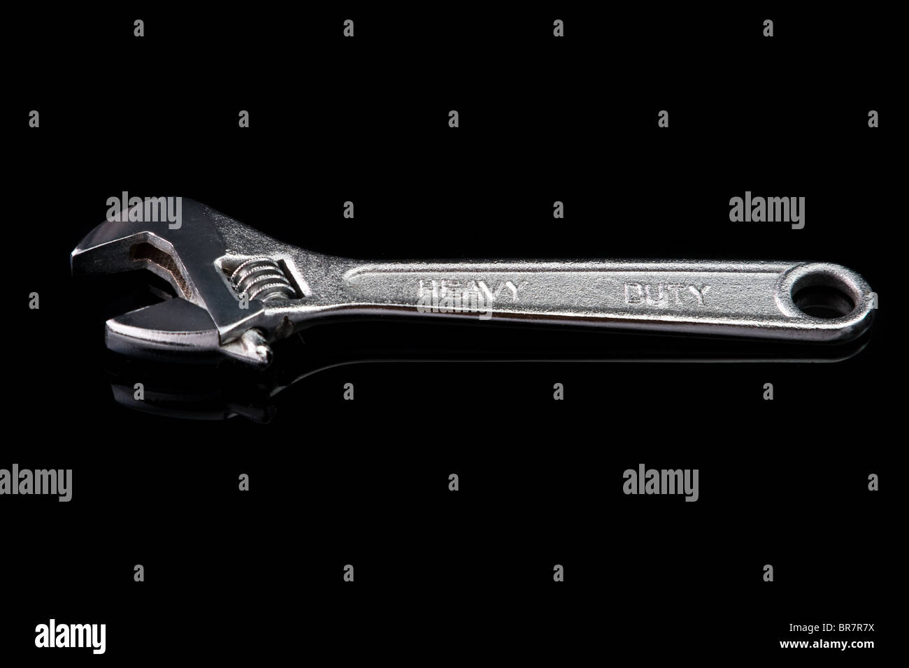 Adjustable chrome wrench. Isolated on black with reflection. Stock Photo