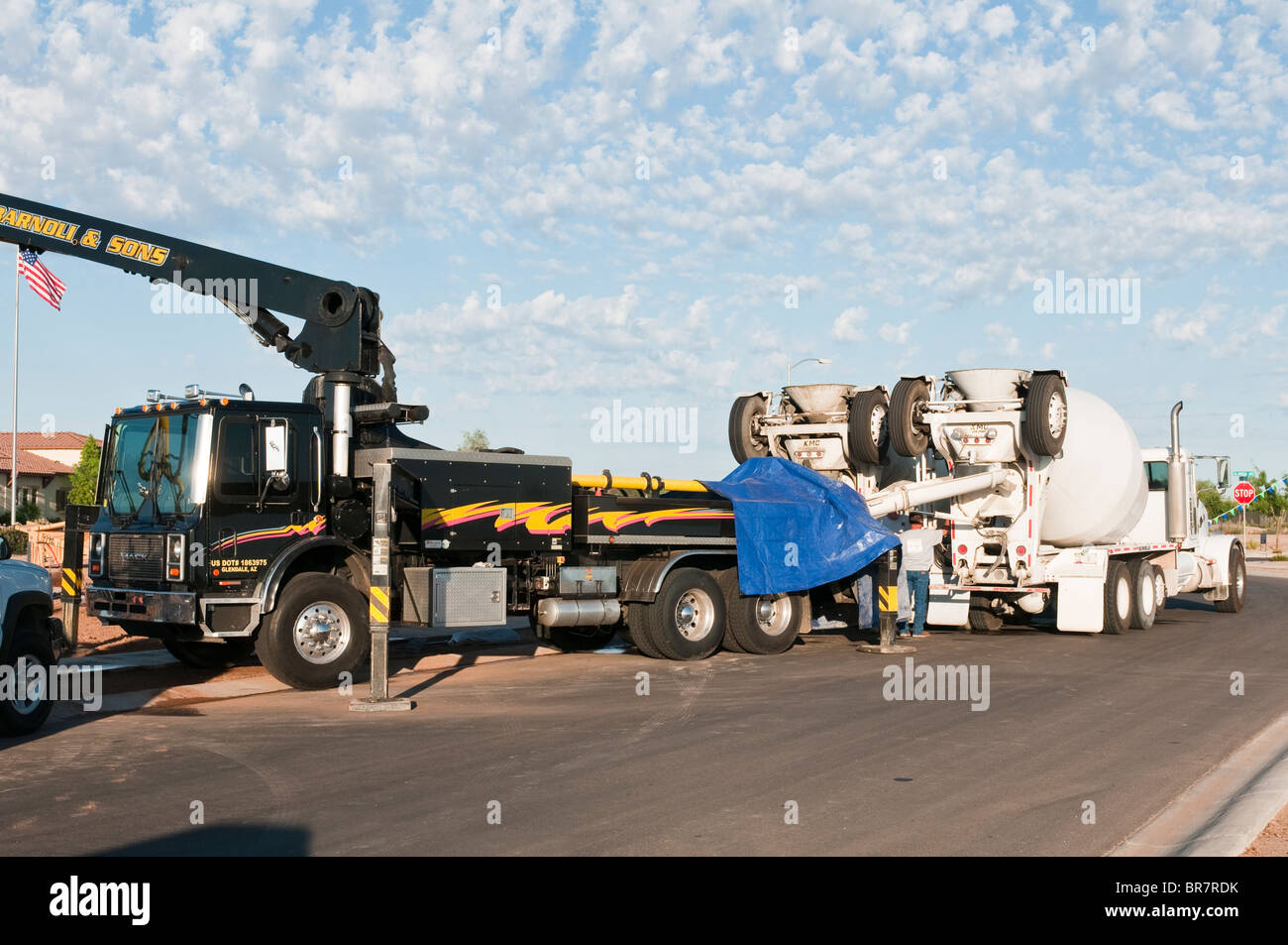 Concrete trucks feed a boom truck used for pumping concrete for a new house under construction in Arizona. Stock Photo