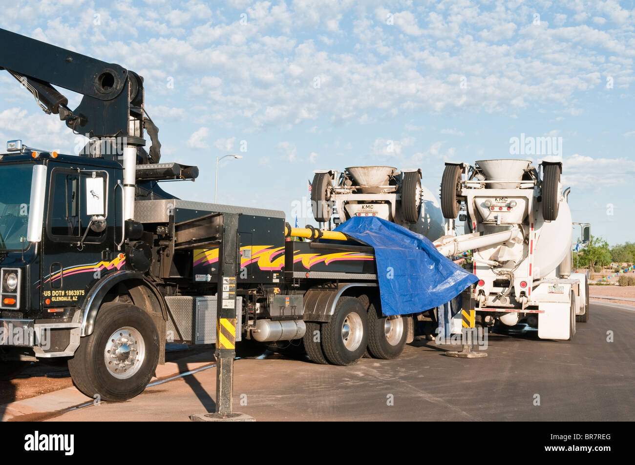 Concrete trucks feed a boom truck used for pumping concrete for a new house under construction in Arizona. Stock Photo