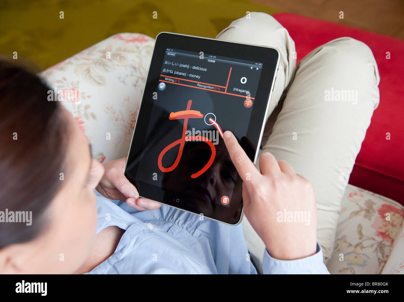 Woman using iPad tablet computer to learn how to write Japanese characters using education application Stock Photo