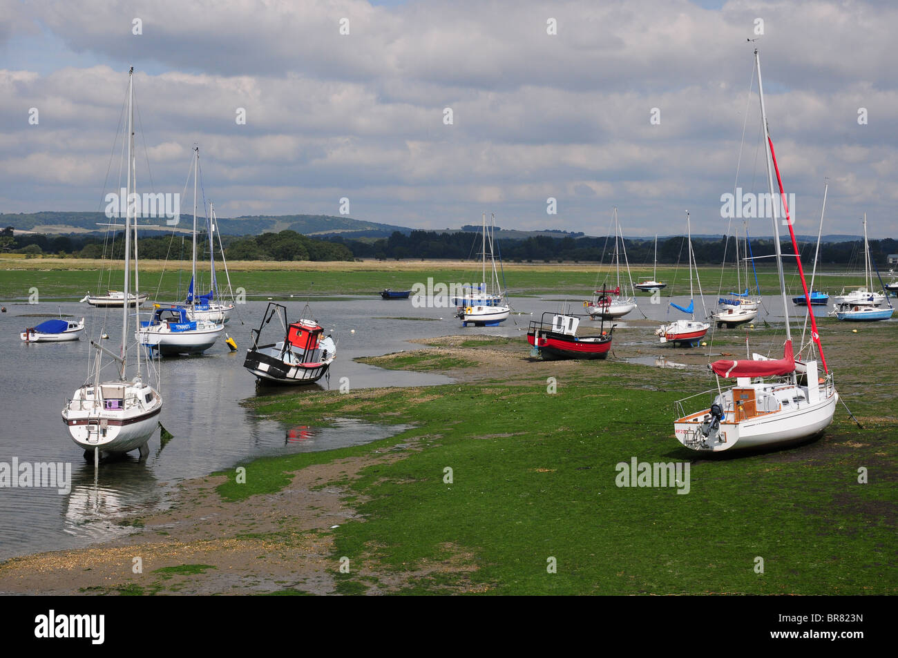 Boats at low tide, cloudy sky, Dell Quay. South Downs behind. Stock Photo
