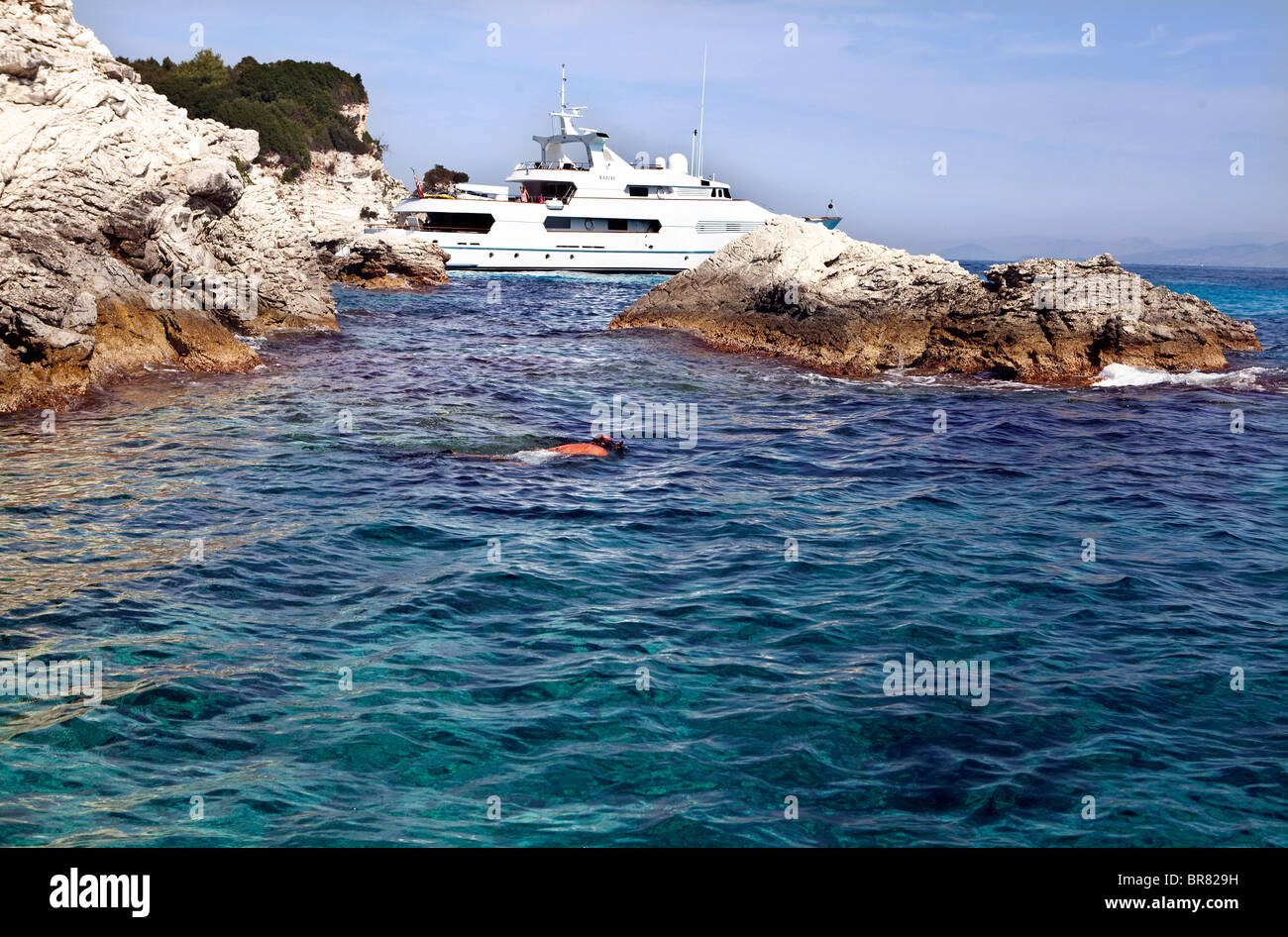 Man snorkeling from boat moored off of Antipaxos, Greece Stock Photo