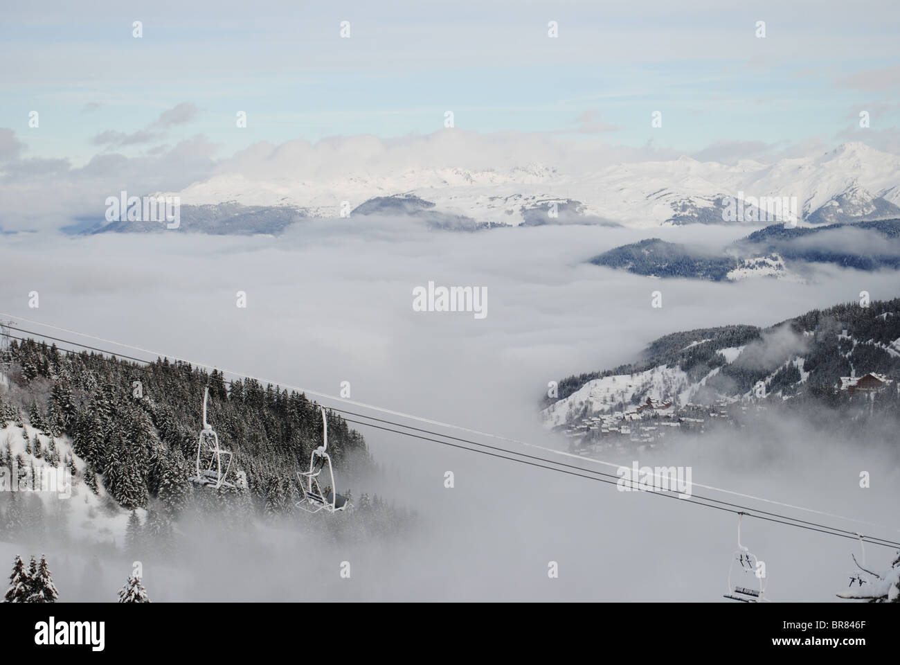 View of the Trois Vallée ski resort covered by cloud in the French Alps. Stock Photo