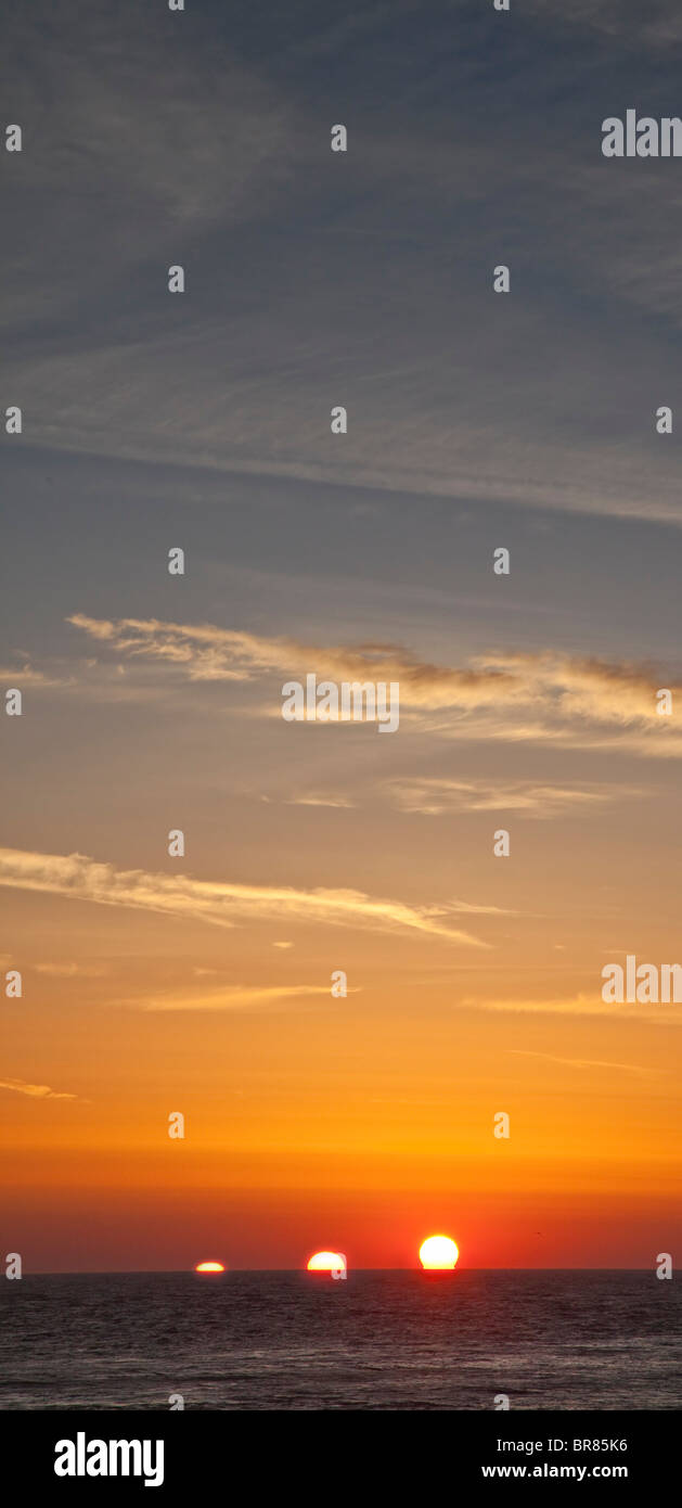 Rising sun over sea, composite showing gradual three positions of sun on horizon Stock Photo