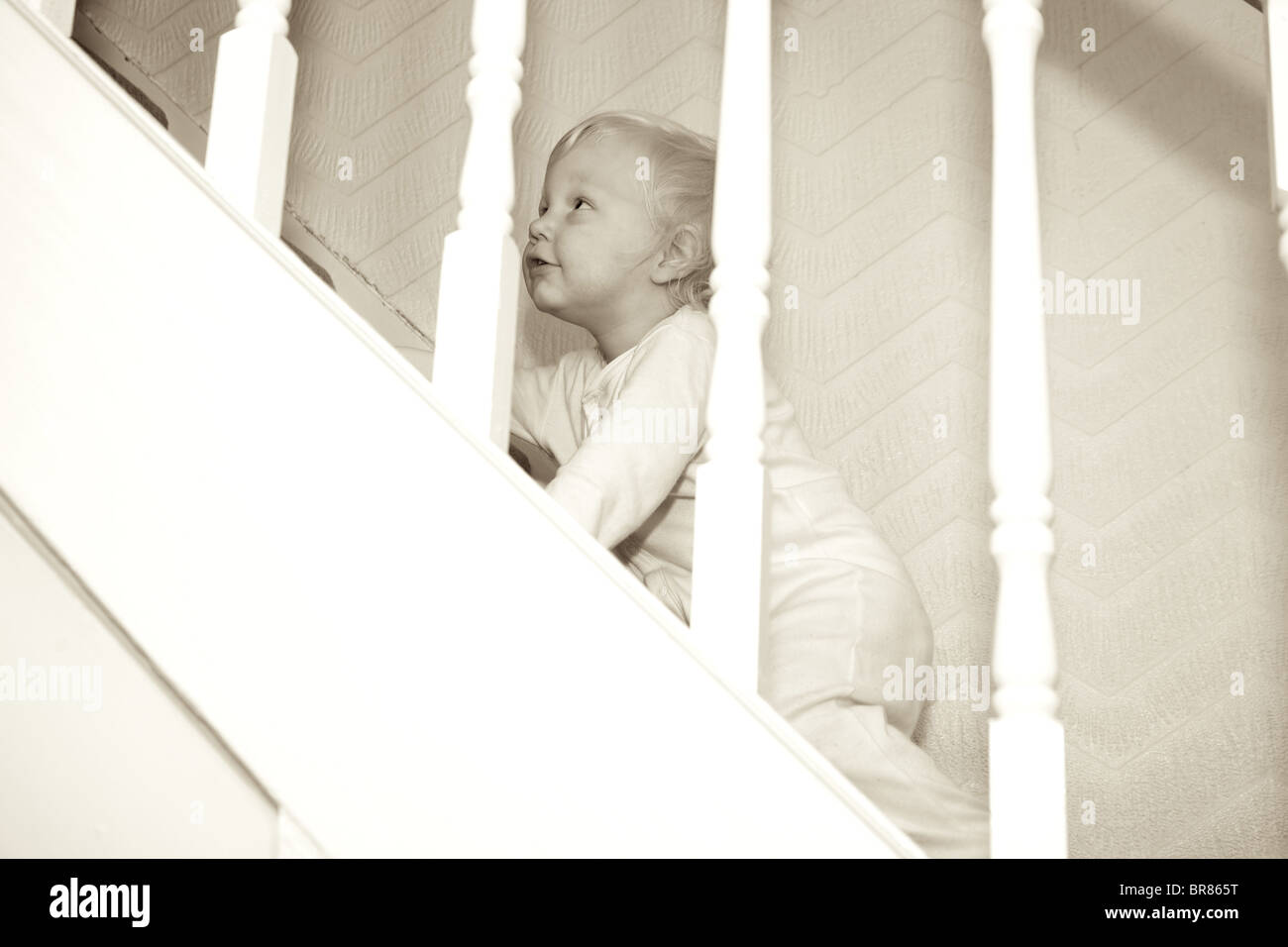 toddler climbing the stairs to bed Stock Photo